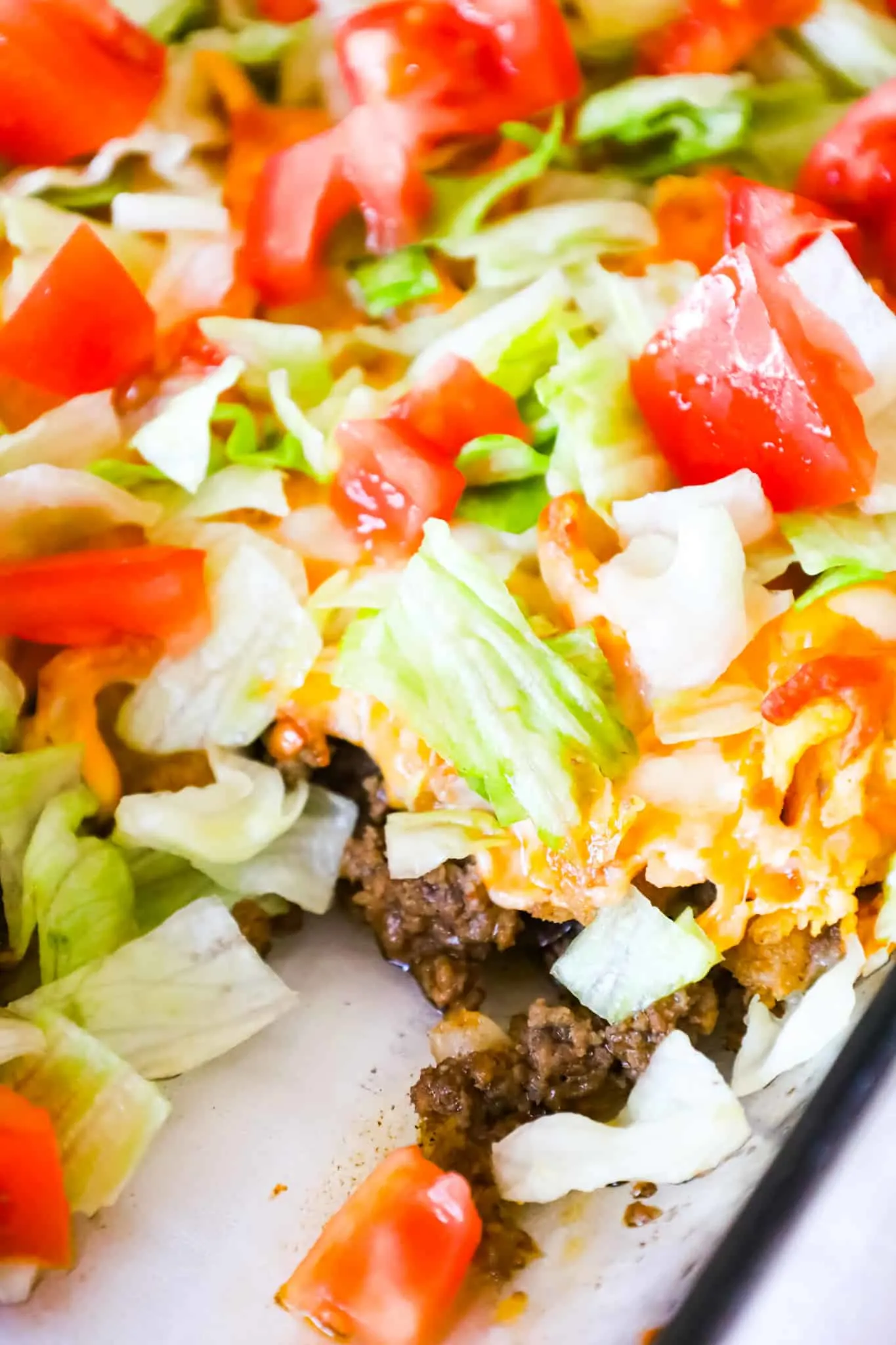 Walking Taco Casserole is an easy ground beef dinner recipe loaded with diced onions, Fritos corn chips, shredded nacho cheese blend, lettuce and diced tomatoes.
