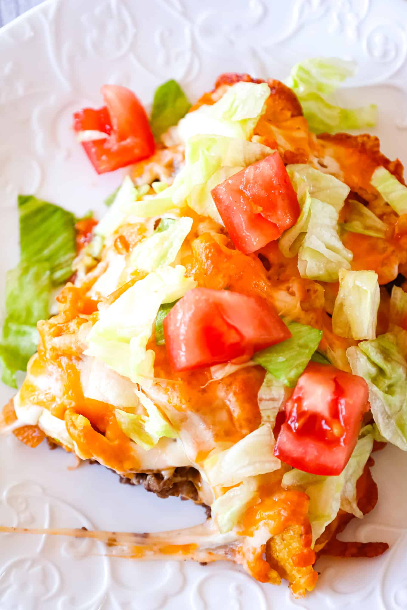 Walking Taco Casserole is an easy ground beef dinner recipe loaded with diced onions, Fritos corn chips, shredded nacho cheese blend, lettuce and diced tomatoes.