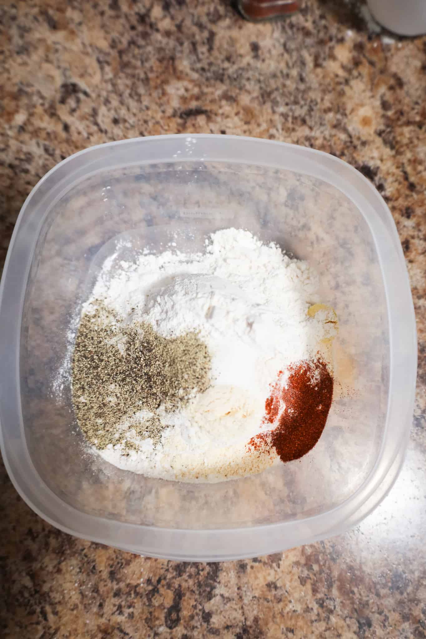 spices on top of all purpose flour in a container