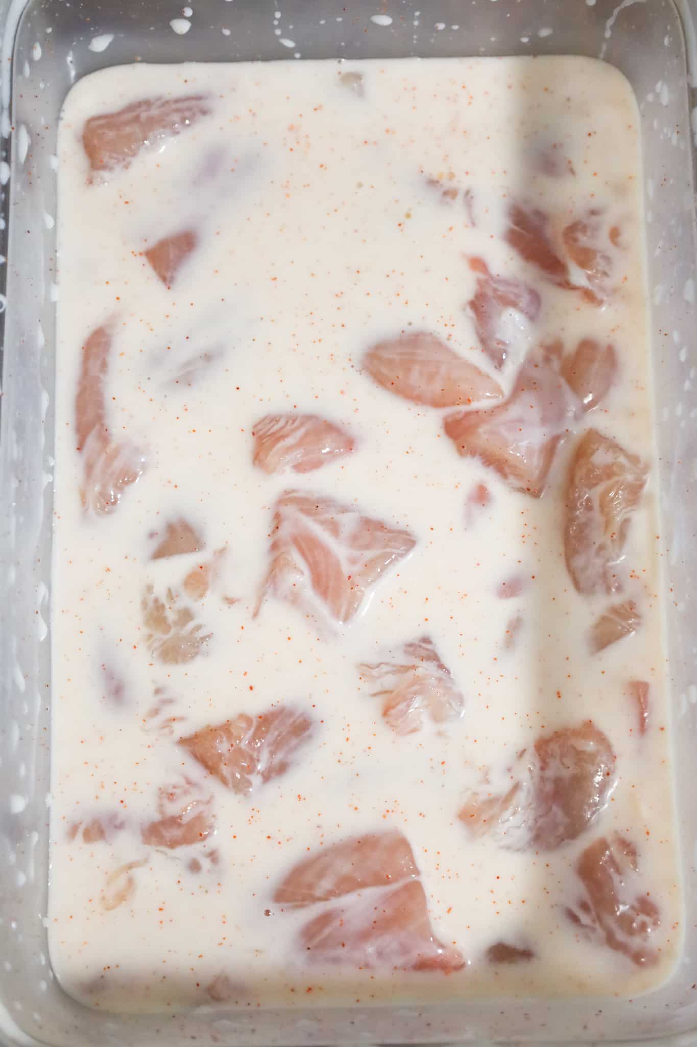 raw chicken breast chunks soaking in buttermilk and spice mixture