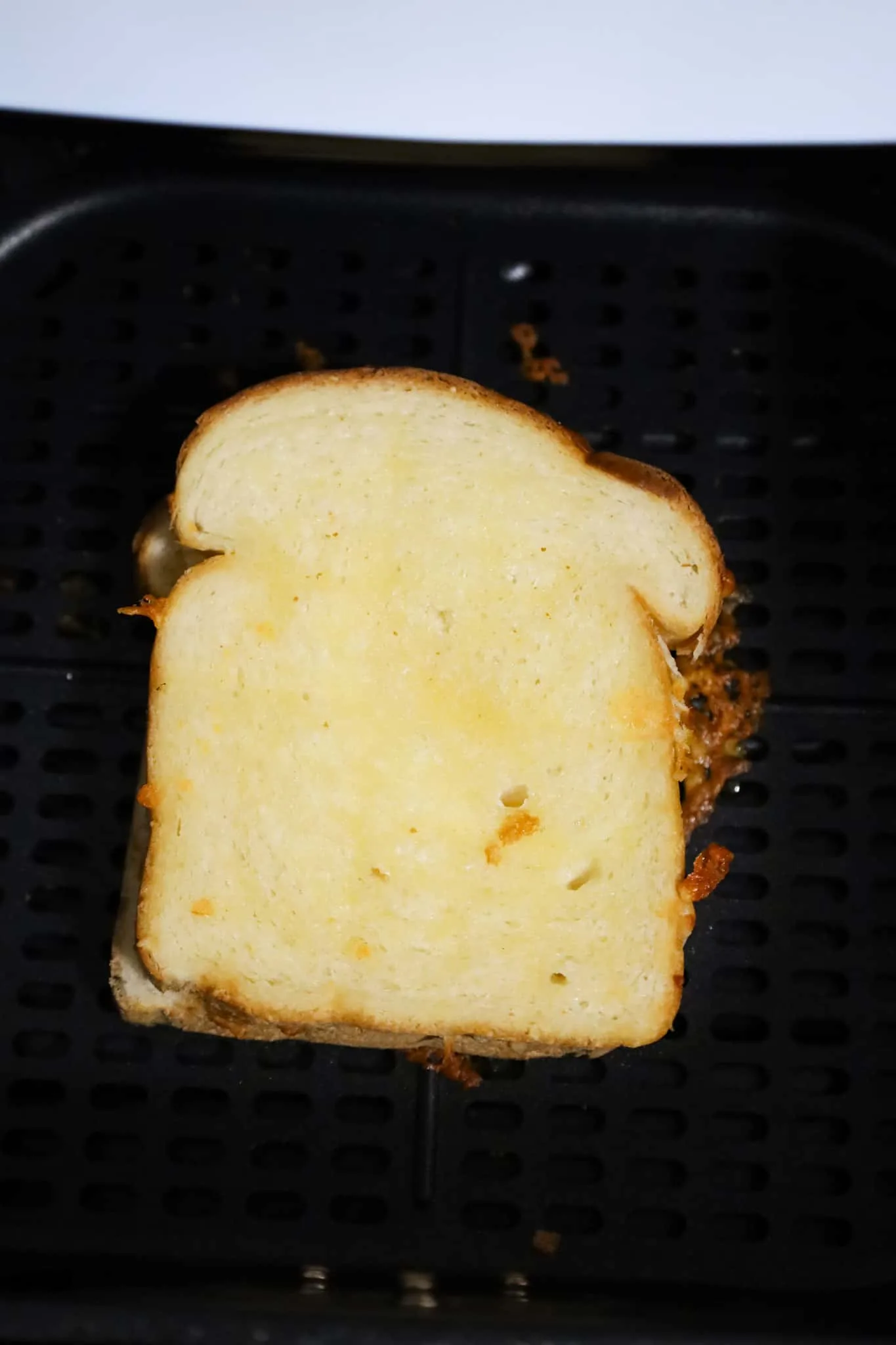 grilled cheese in air fryer basket after removing toothpicks and flipping