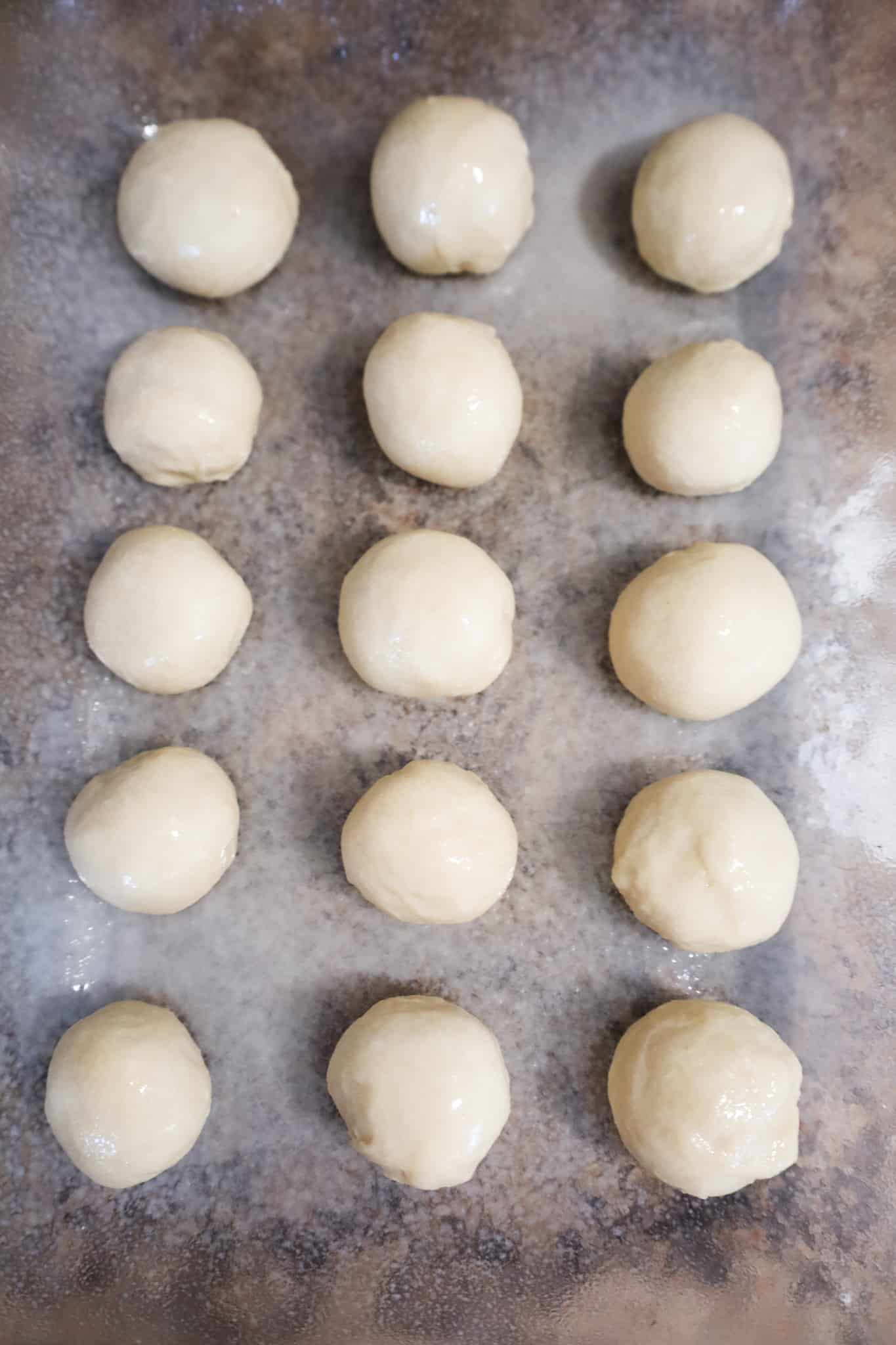 dough balls in a baking dish sprayed with butter flavoured cooking spray