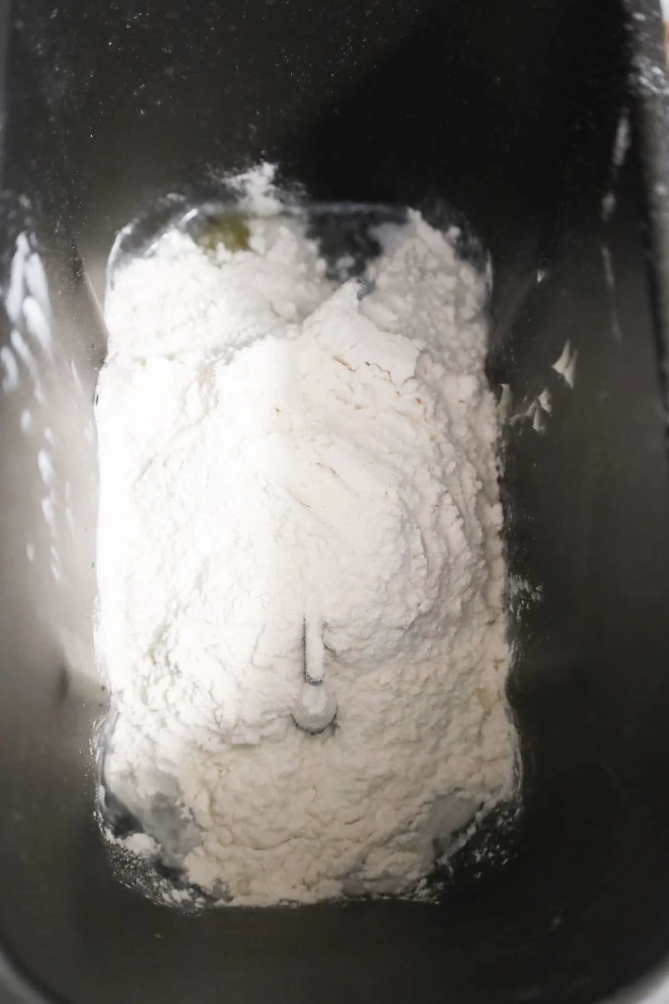 flour on top of wet ingredients in a bread machine pan