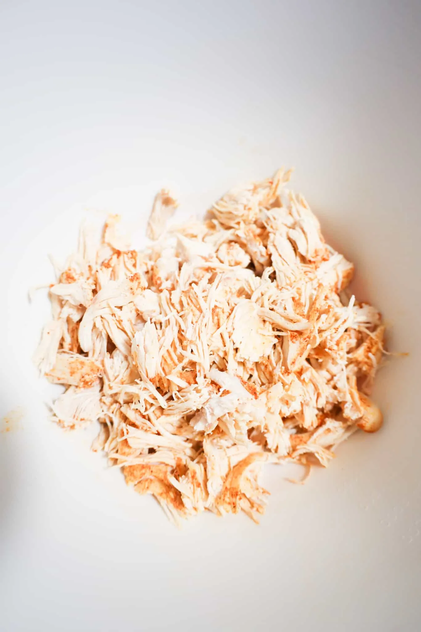 shredded rotisserie chicken in a mixing bowl