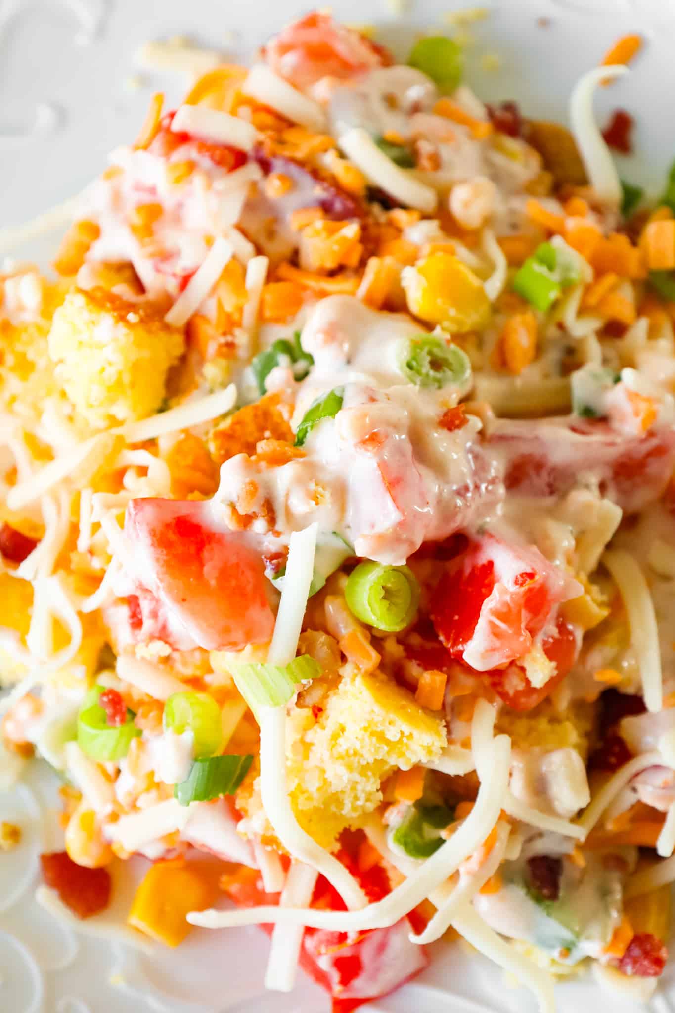 Cornbread Salad is a tasty side dish recipe loaded with cornbread pieces, diced tomatoes, diced bell peppers, corn, shredded cheese, chopped green onions, crumbled bacon and a dressing made from sour cream, ranch and salsa.