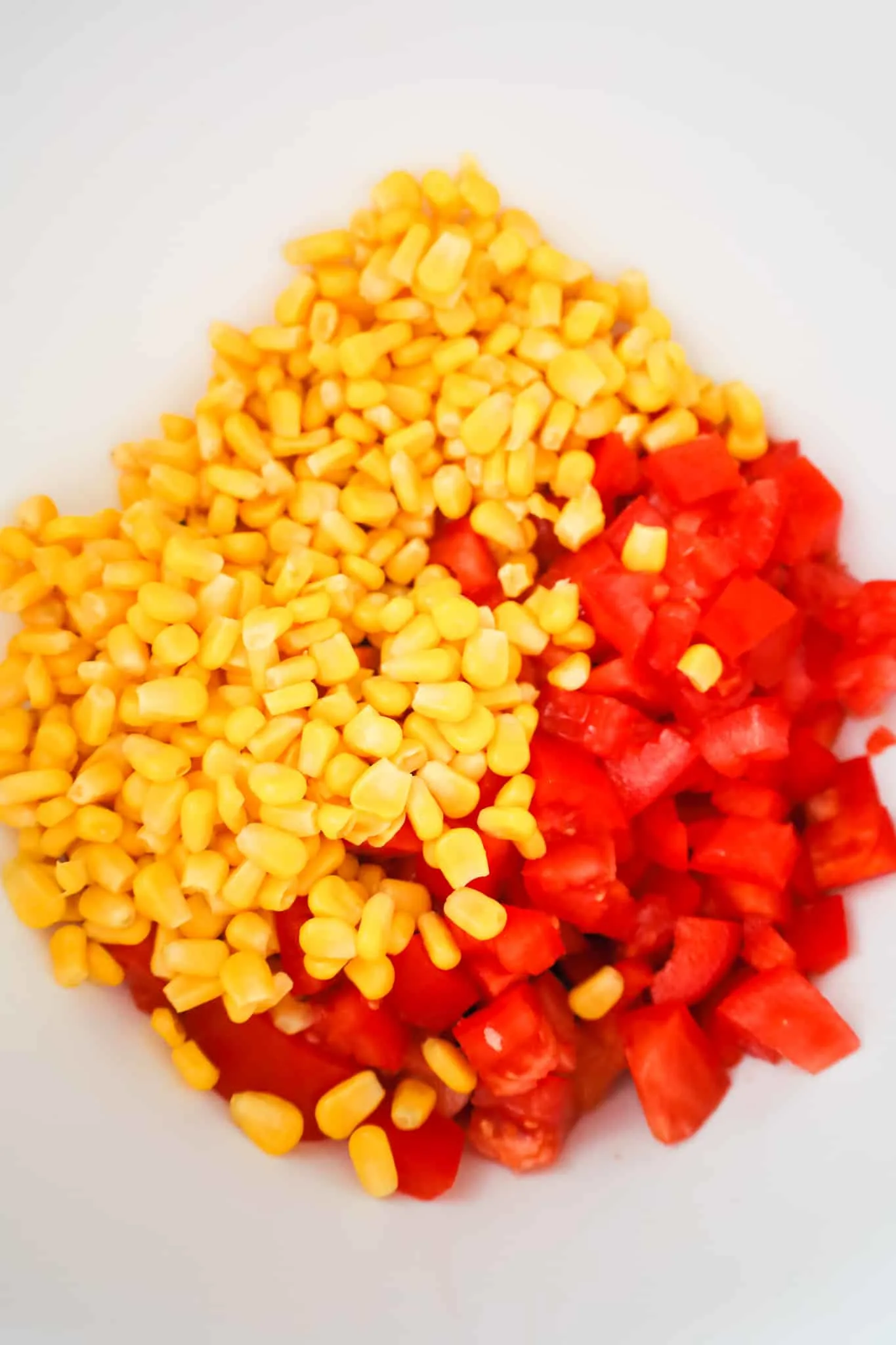 corn and diced tomatoes in a mixing bowl