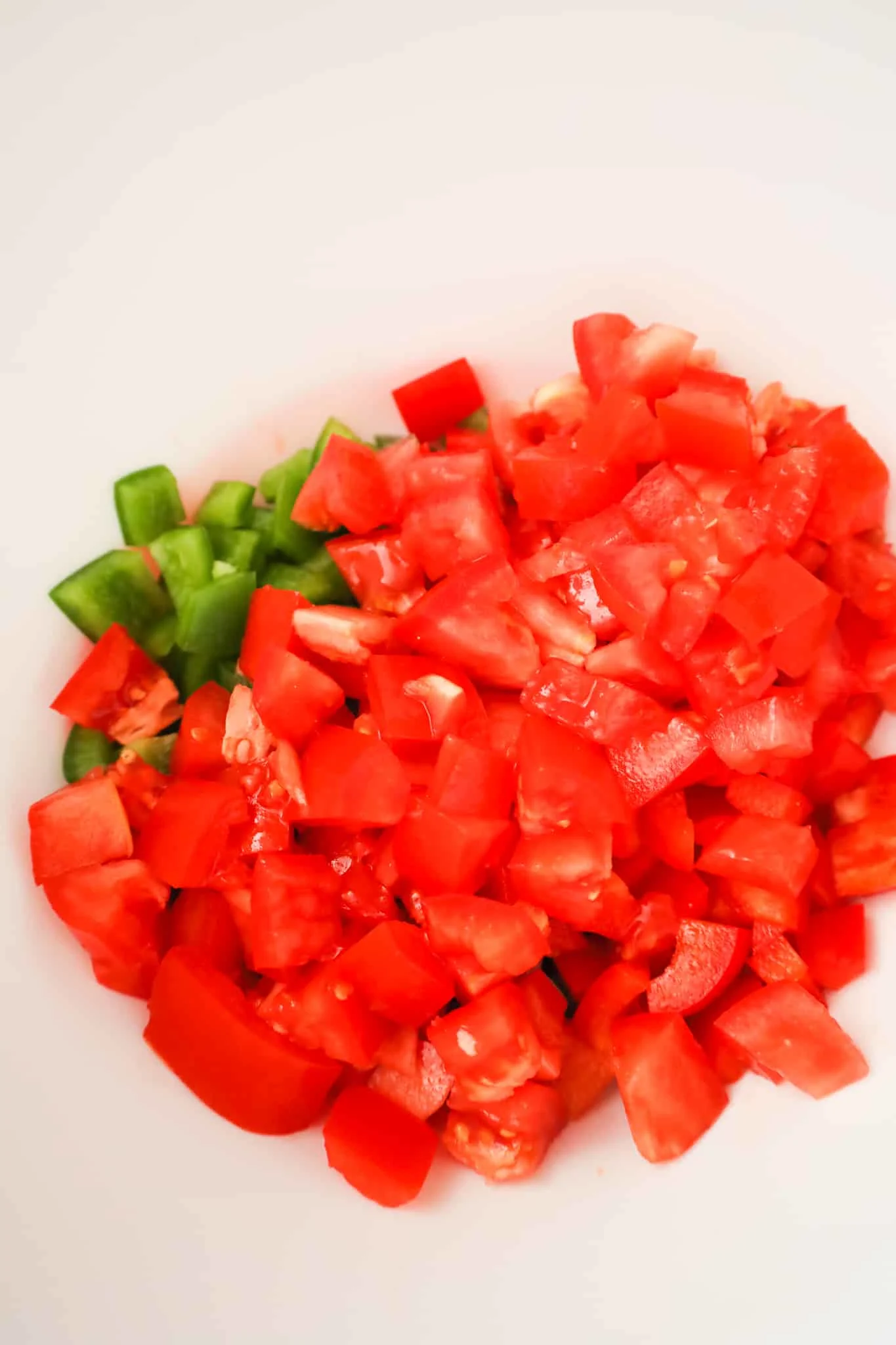 diced tomatoes and diced peppers in a mixing bowl