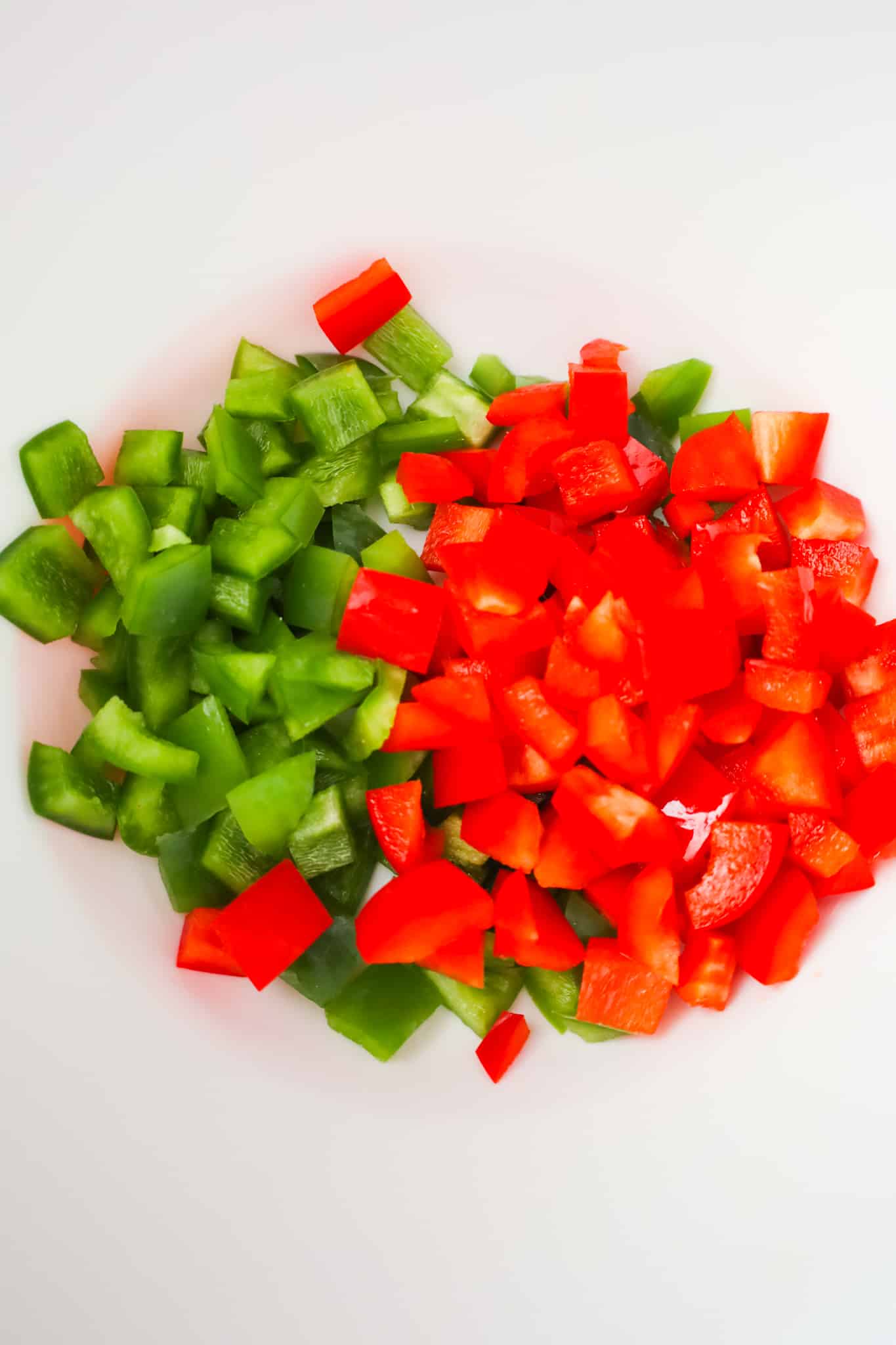 diced green peppers and red peppers in a mixing bowl