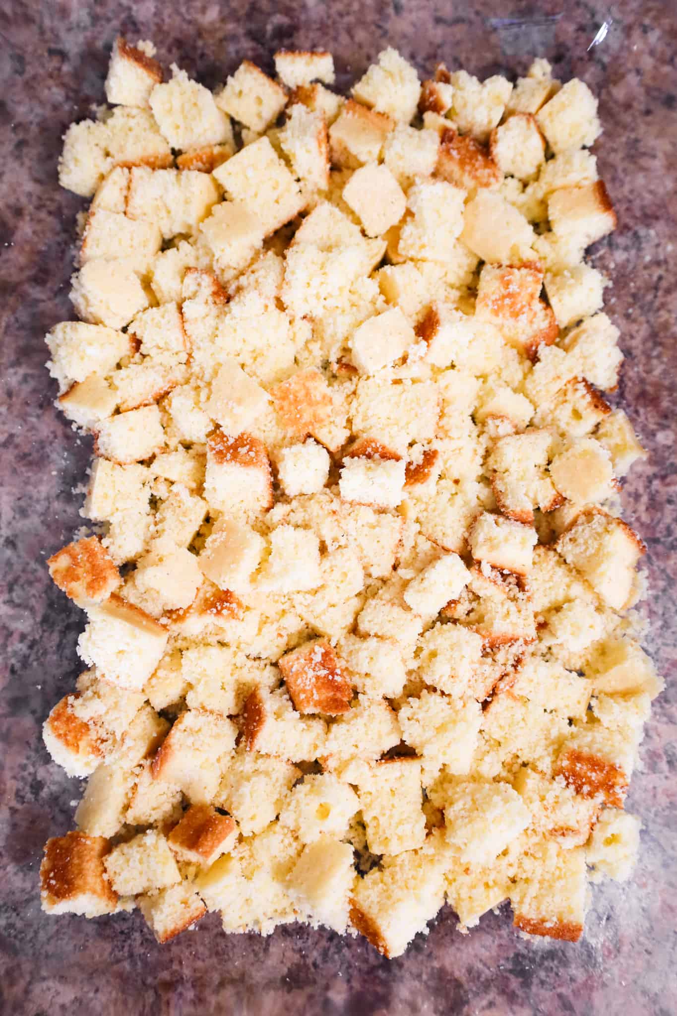 cornbread cubes in the bottom of a 9 x 13 inch glass dish