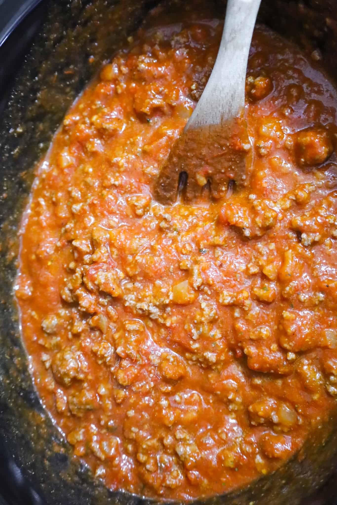 uncooked spaghetti noodles on top of marinara sauce in a crock pot