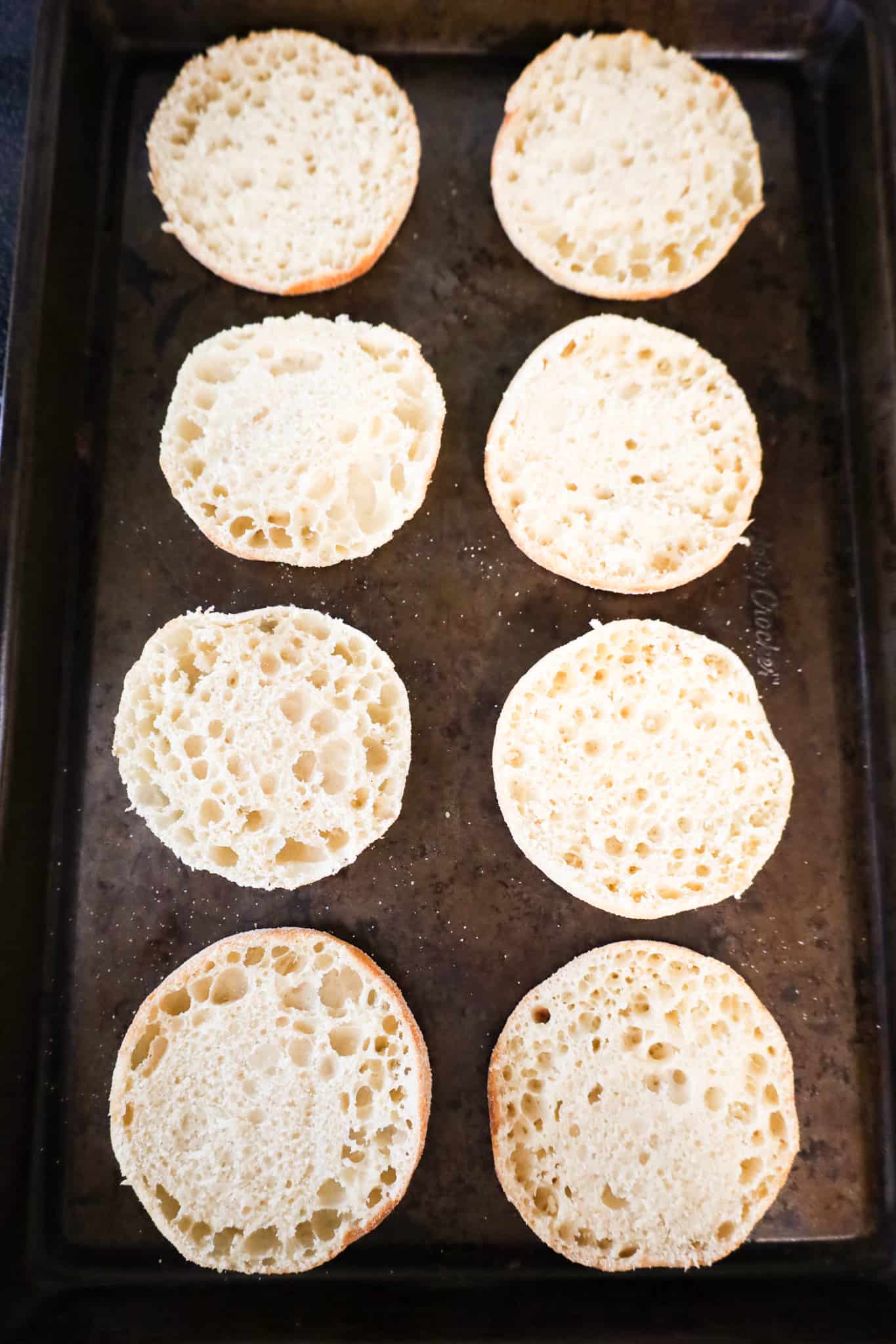 split English muffins on a baking sheet