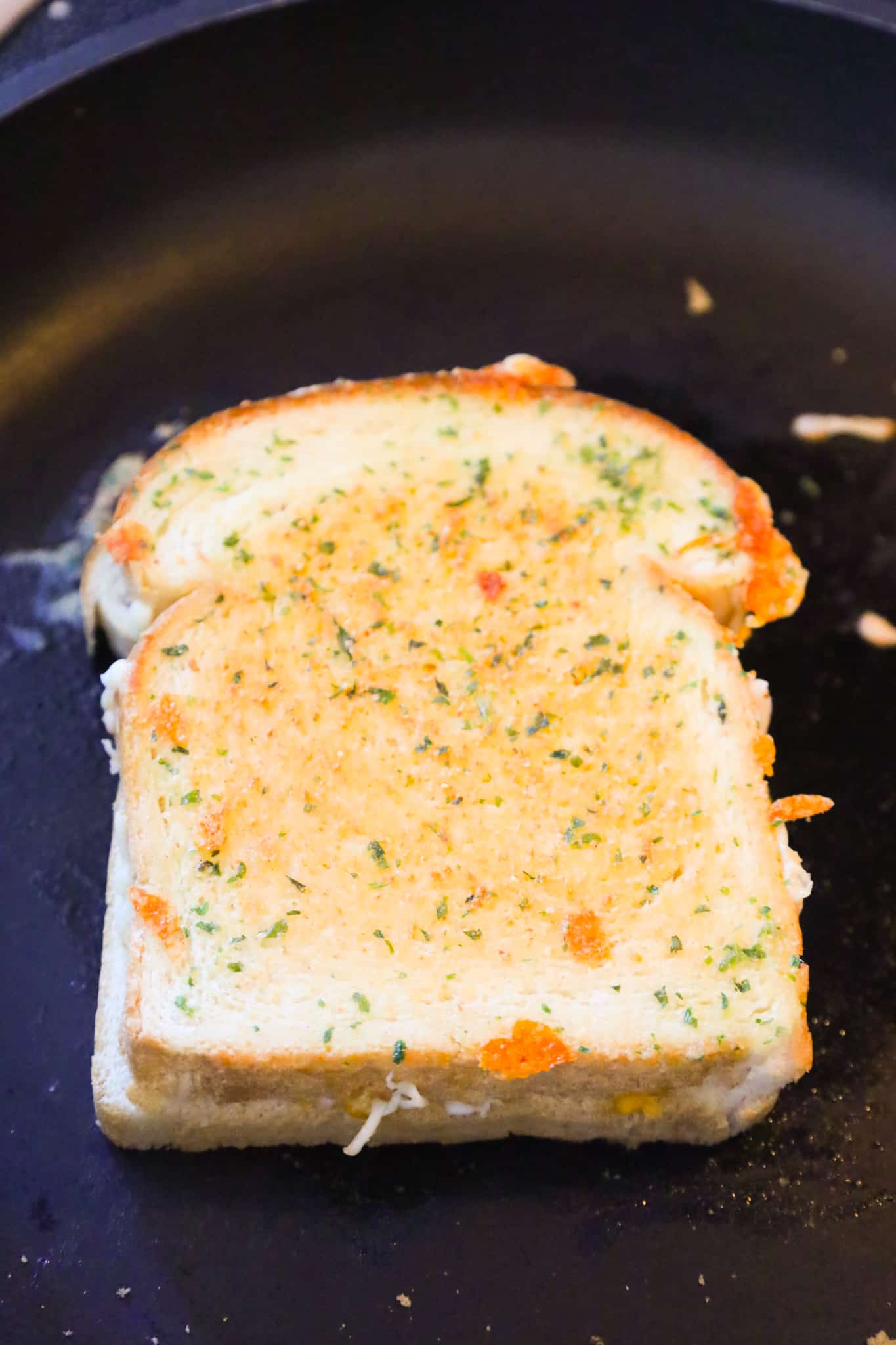 garlic bread grilled cheese cooking in a saute pan