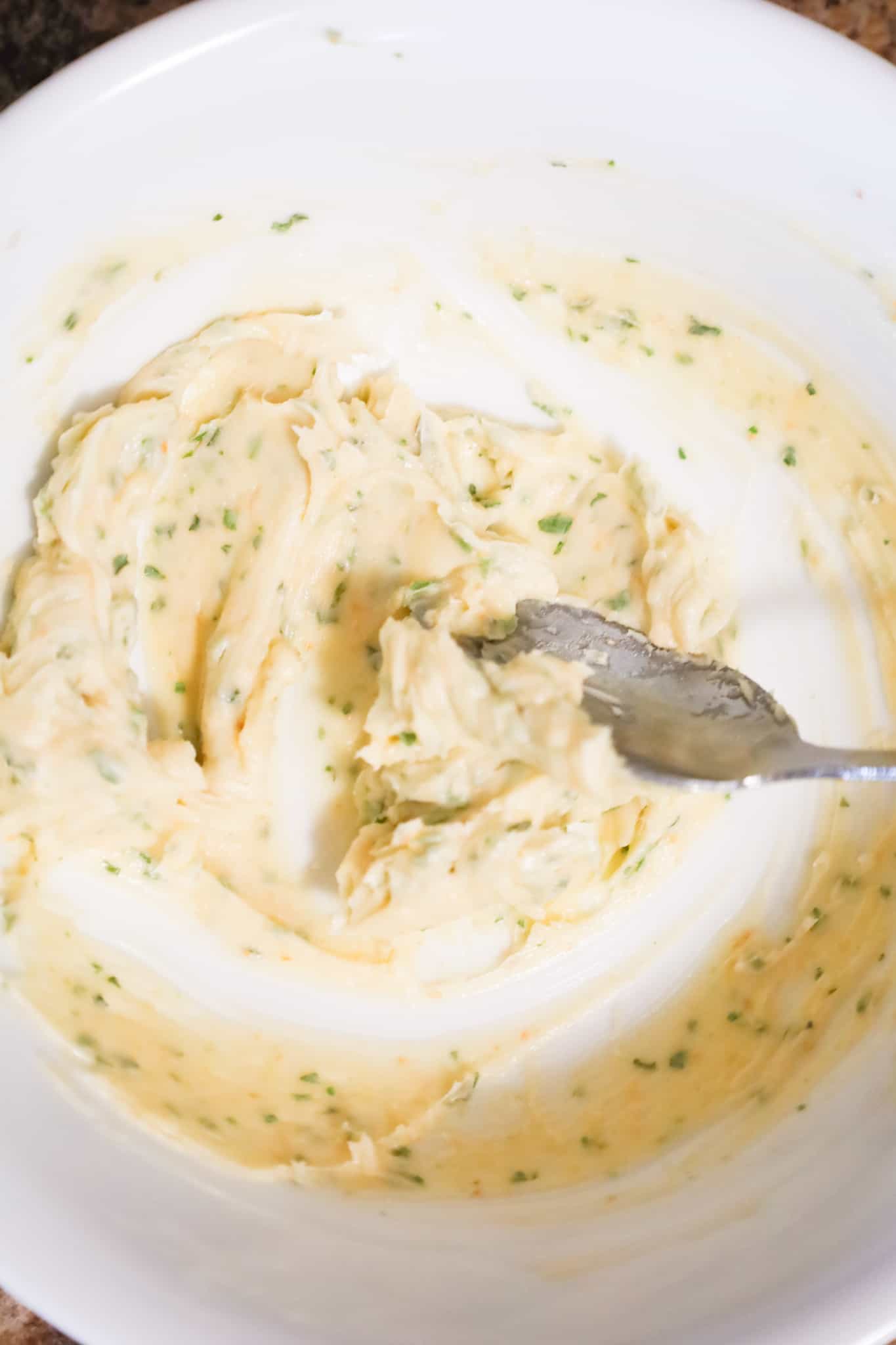 garlic butter being stirred in a mixing bowl