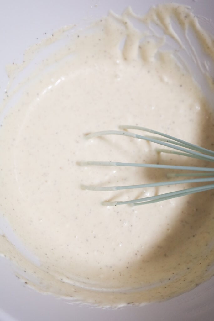 mayo based macaroni salad dressing mixture in a mixing bowl