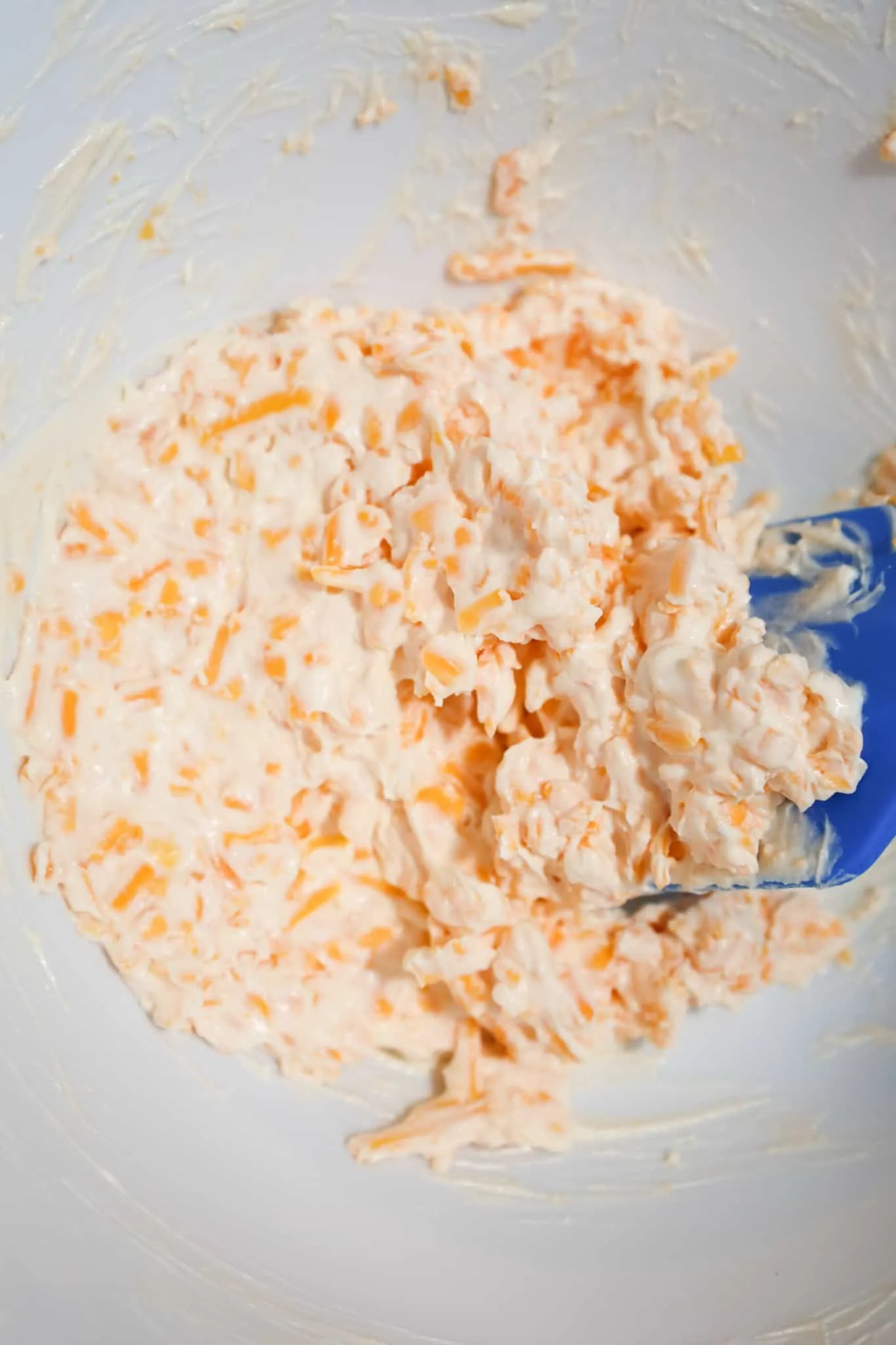 cream cheese and cheddar cheese mixture in a mixing bowl