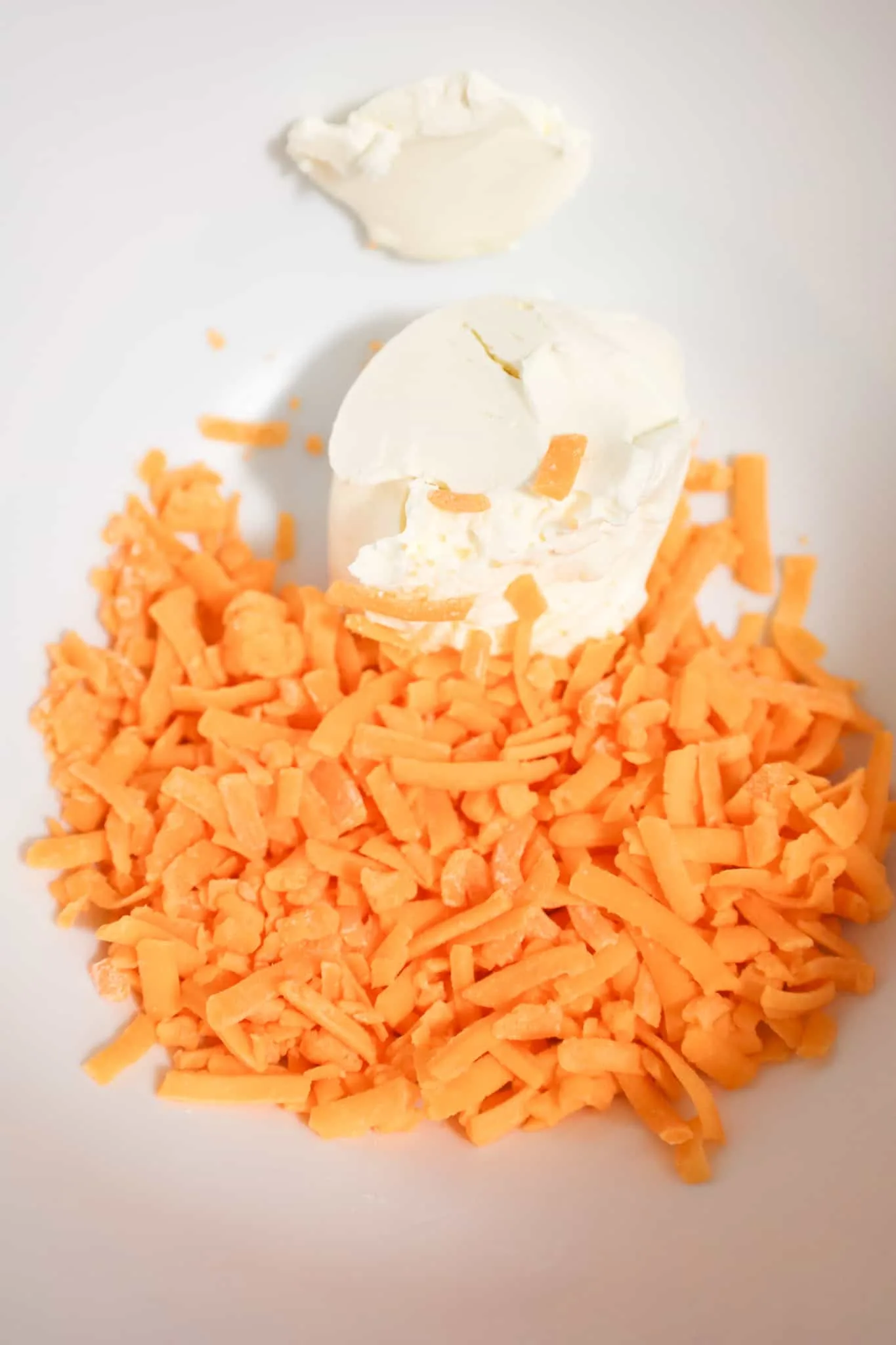 cream cheese and shredded cheddar cheese in a mixing bowl