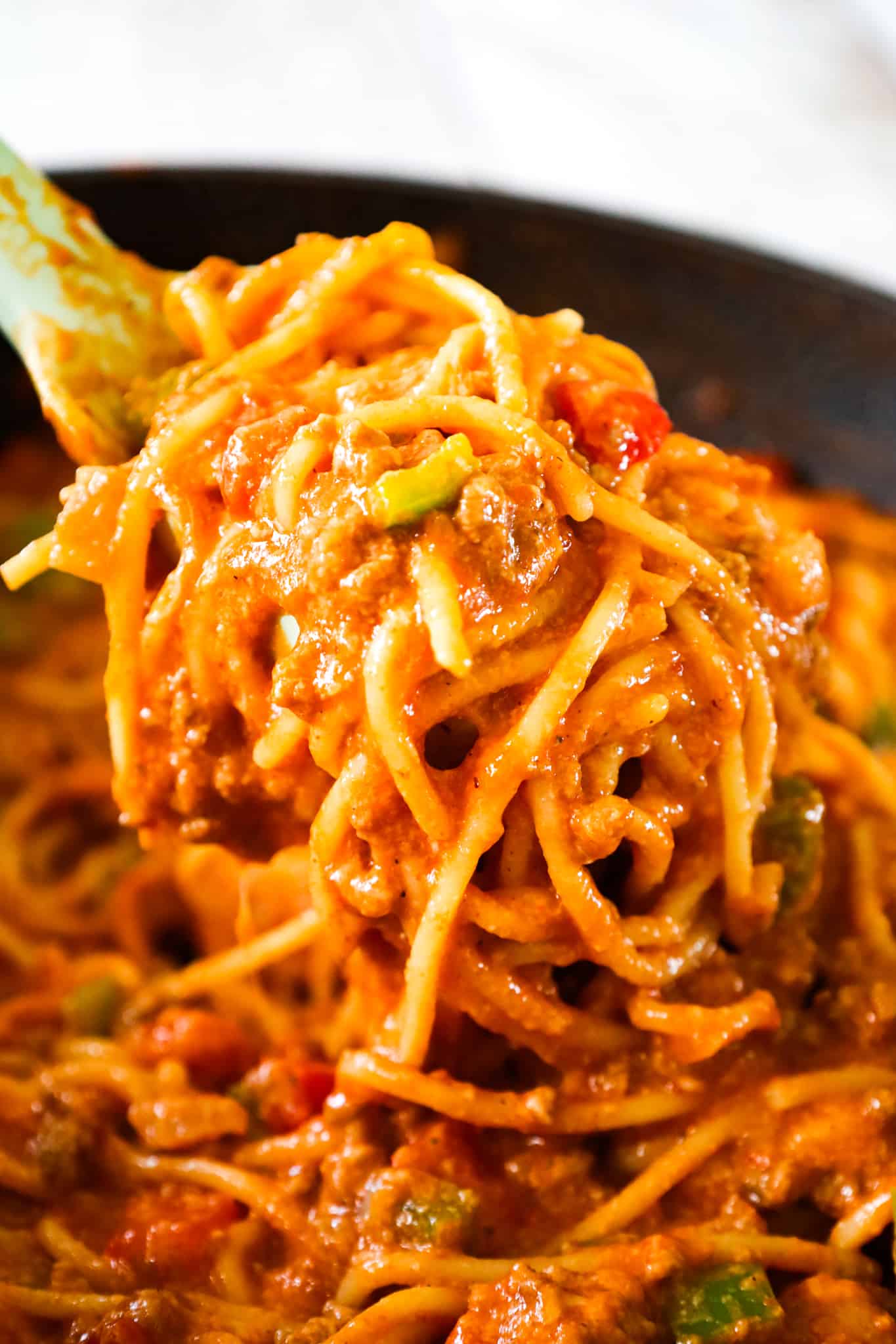 Mexican Spaghetti is a hearty pasta recipe loaded with ground beef, red peppers, green peppers, onions, Rotel diced tomatoes and green chilies, taco seasoning and shredded cheese.