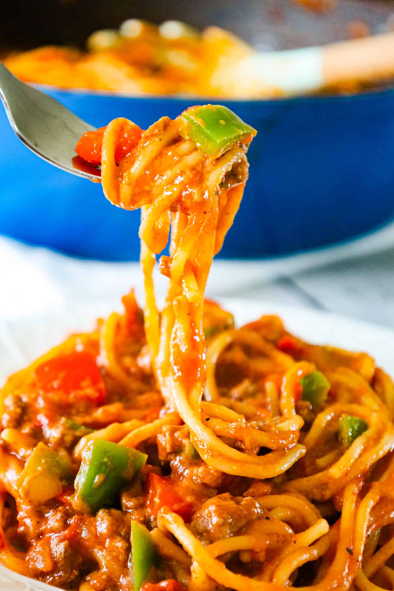 Mexican Spaghetti is a hearty pasta recipe loaded with ground beef, red peppers, green peppers, onions, Rotel diced tomatoes and green chilies, taco seasoning and shredded cheese.