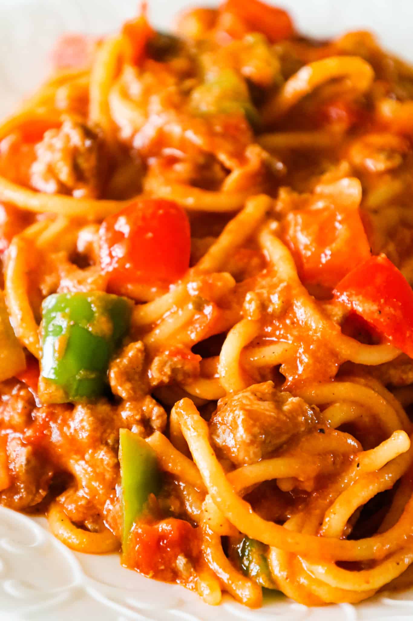 Mexican Spaghetti is a hearty pasta recipe loaded with ground beef, red peppers, green peppers, onions, Rotel diced tomatoes and green chilies, taco seasoning and shredded cheese.