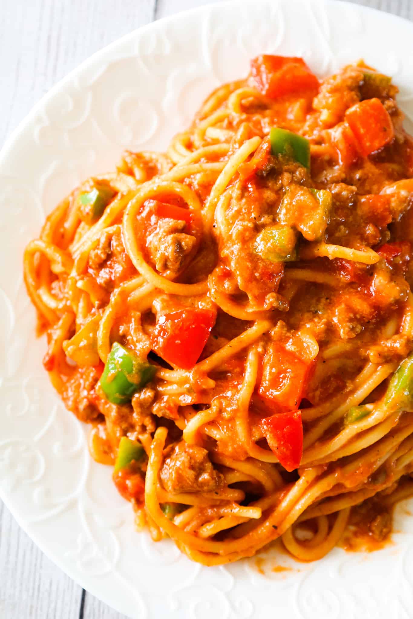 Mexican Spaghetti is a hearty pasta recipe loaded with ground beef, red peppers, green peppers, onions, Rotel diced tomatoes and green chilies, taco seasoning and shredded cheese.