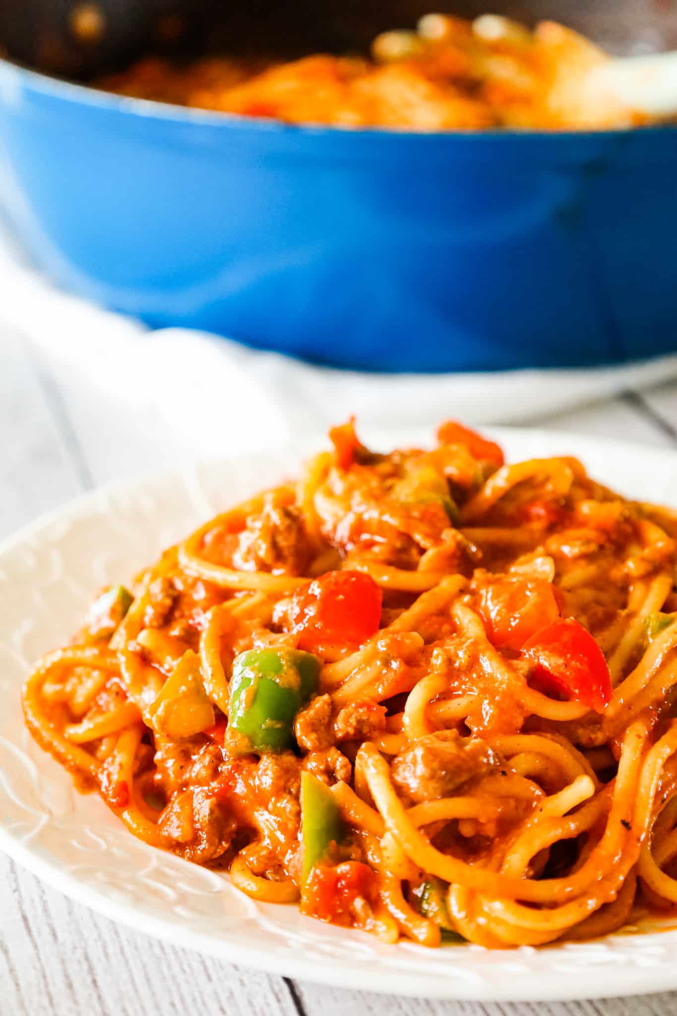 Mexican Spaghetti is a hearty pasta recipe loaded with ground beef, red peppers, green peppers, onions, Rotel diced tomatoes and green chilies, taco seasoning and shredded cheese.