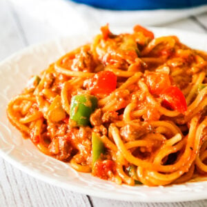 Mexican Spaghetti is a hearty pasta recipe loaded with ground beef, red peppers, green peppers, onions, Rotel diced tomatoes and green chilies, taco seasoning and shredded cheese.