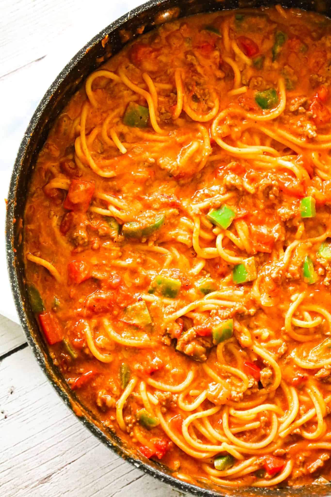 Mexican Spaghetti is a hearty pasta recipe loaded with ground beef, red peppers, green peppers, onions, Rotel diced tomatoes and green chilies, taco seasoning and shredded cheese.