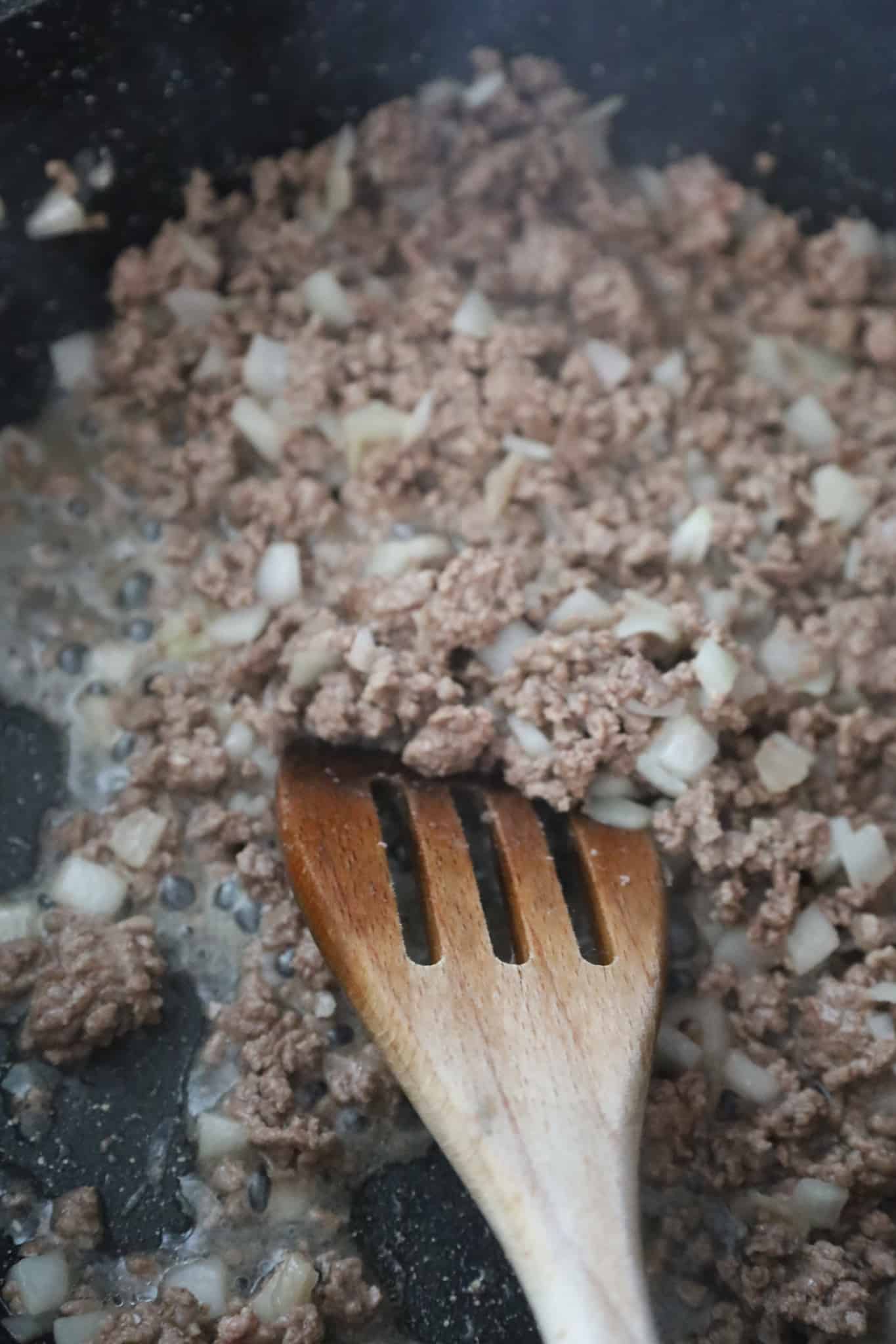 cooked ground beef and diced onions in a saute pan