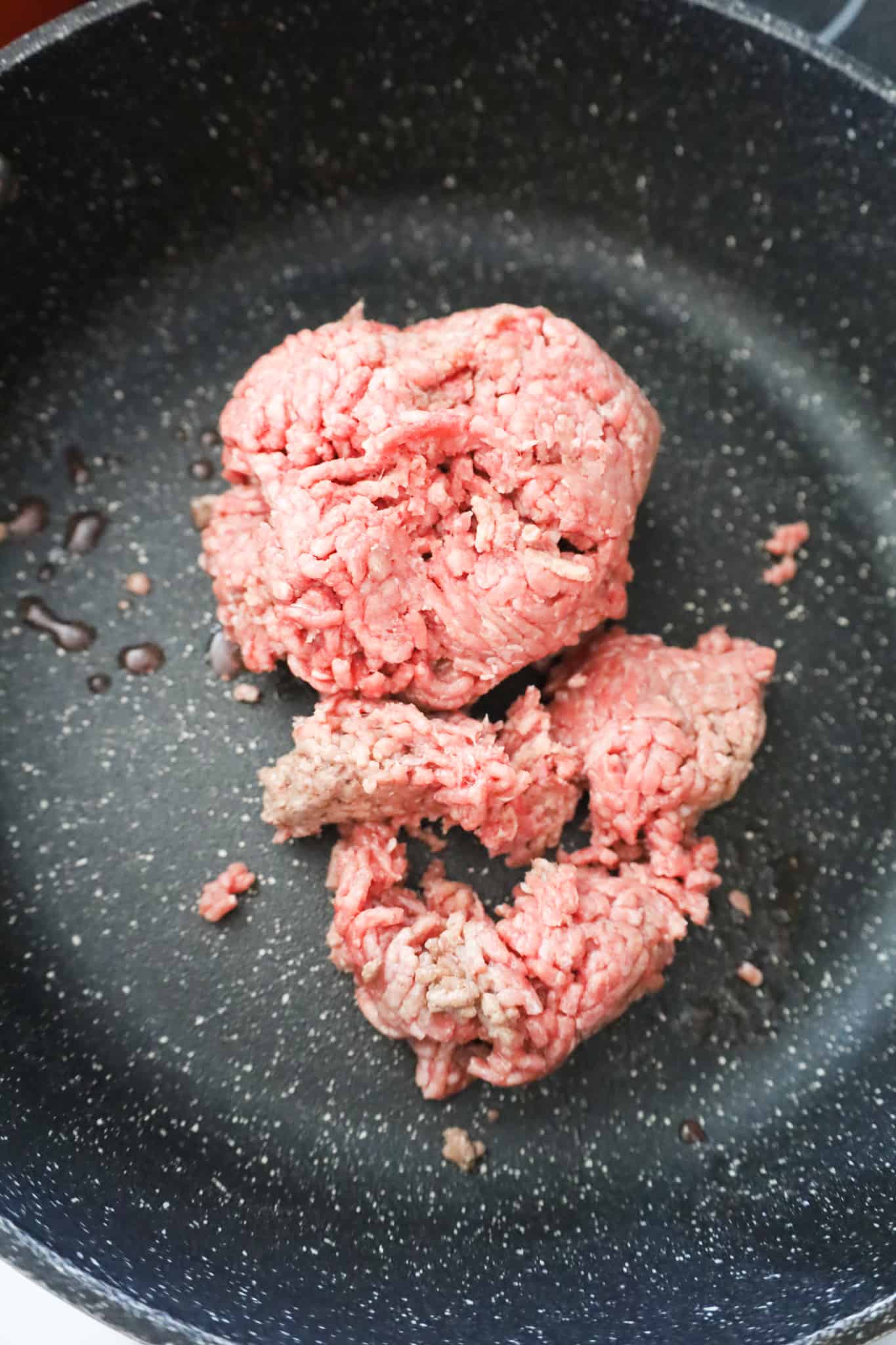 raw ground beef in a saute pan