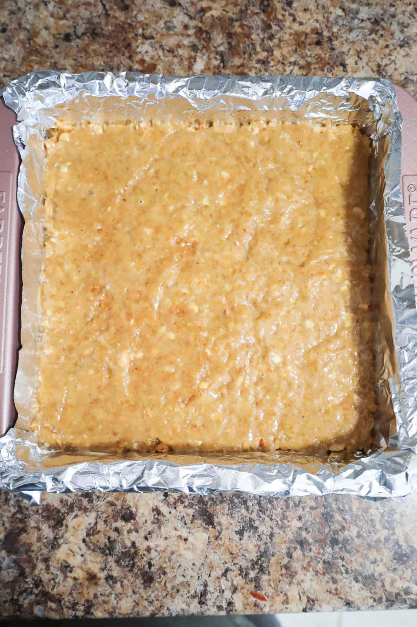 peanut butter cornflake mixture in a baking pan