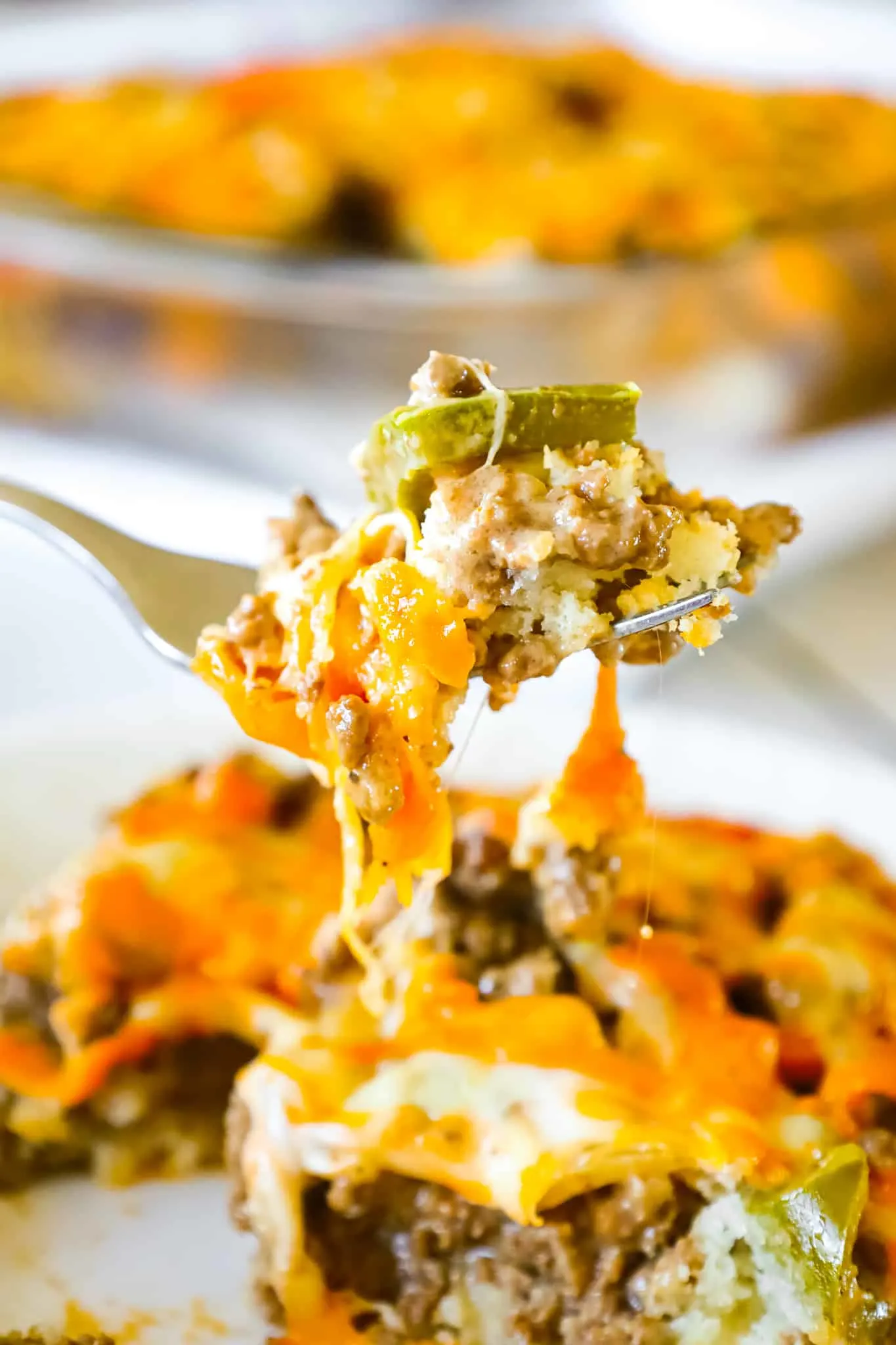 Philly Cheese Steak Casserole is an easy ground beef casserole recipe with a Bisquick base and loaded with green peppers, onions, mozzarella and cheddar cheese.