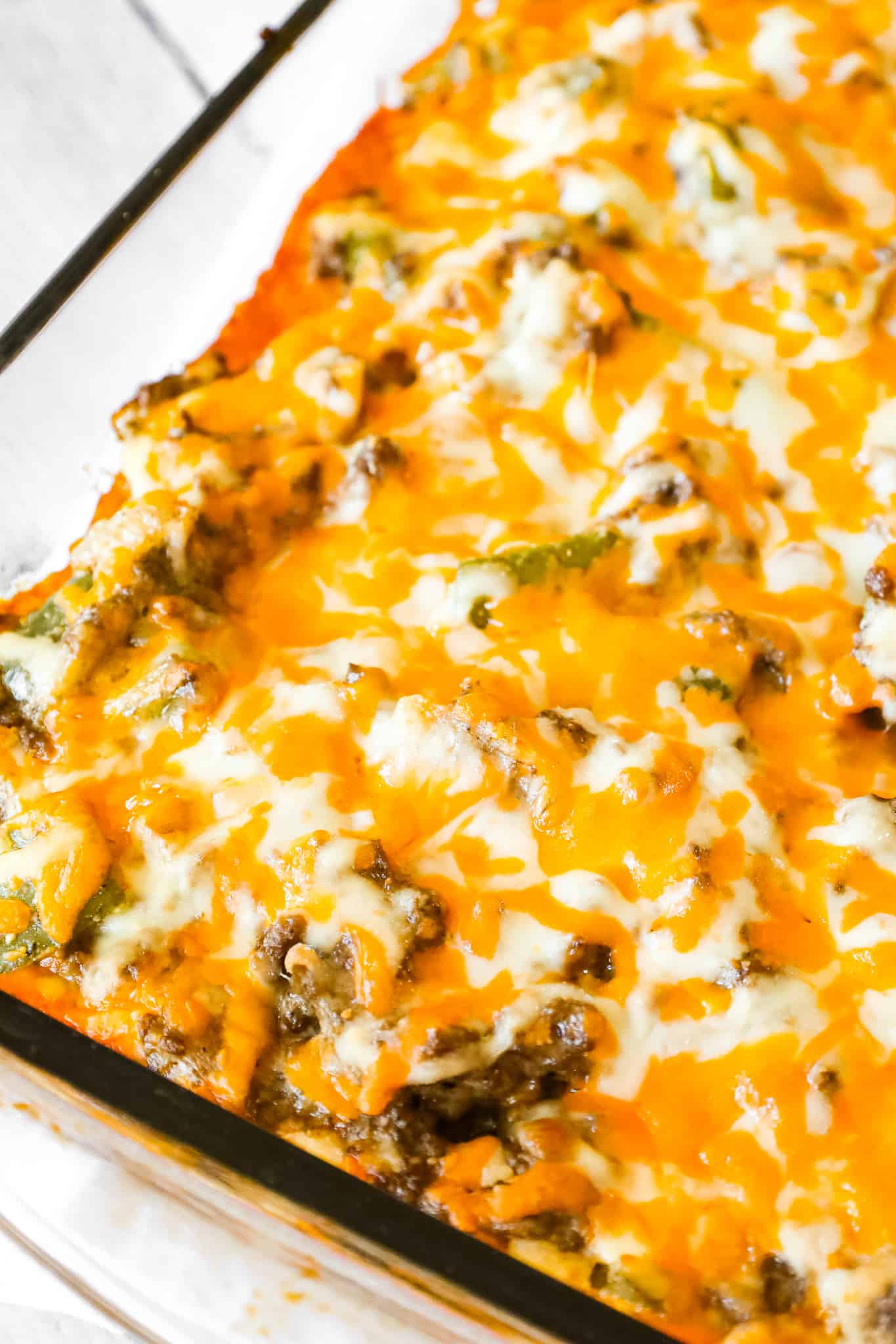 Philly Cheese Steak Casserole is an easy ground beef casserole recipe with a Bisquick base and loaded with green peppers, onions, mozzarella and cheddar cheese.