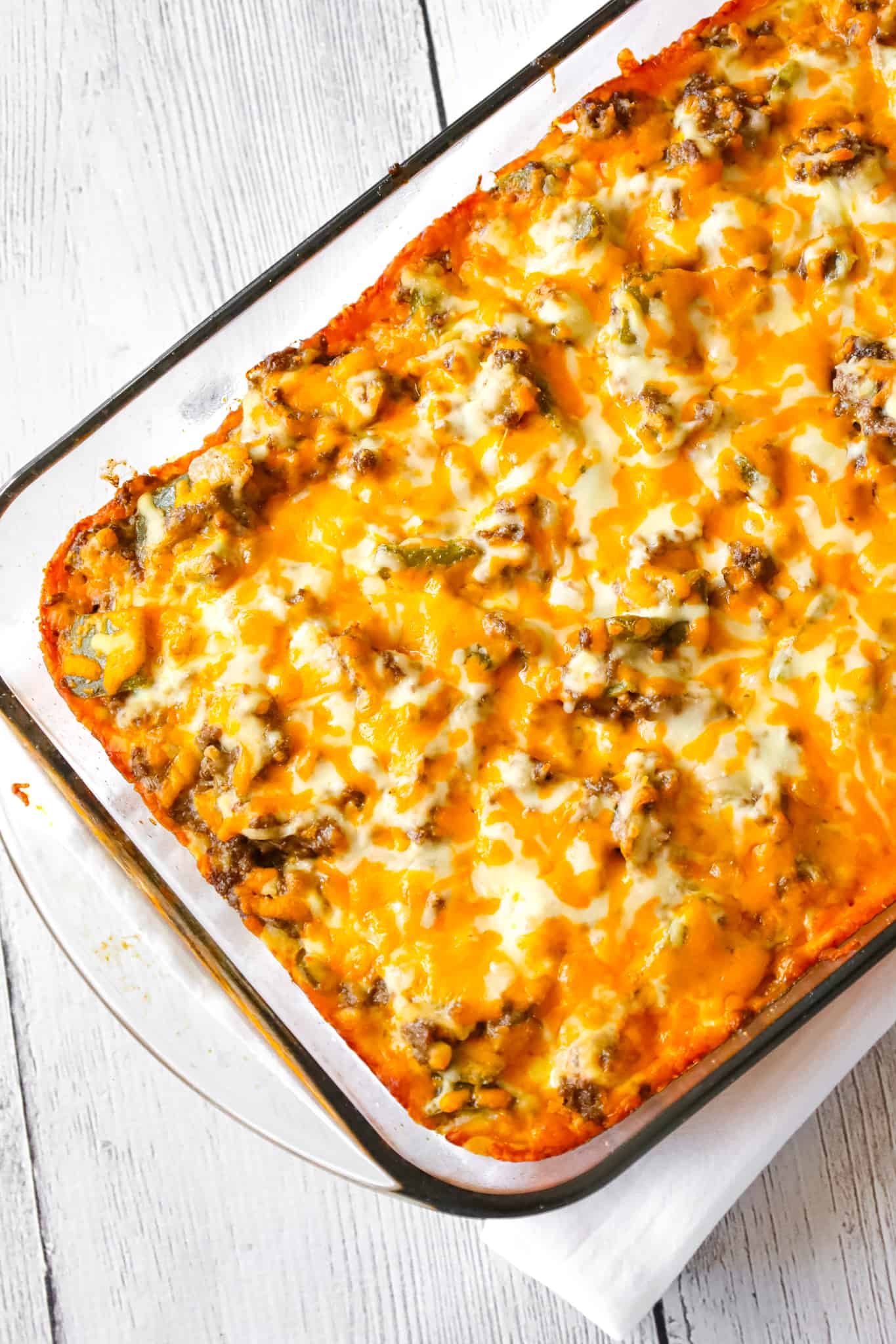 Philly Cheese Steak Casserole is an easy ground beef casserole recipe with a Bisquick base and loaded with green peppers, onions, mozzarella and cheddar cheese.