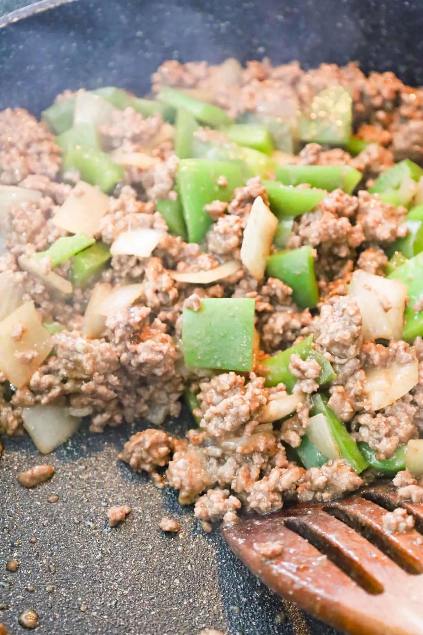 ground beef, diced green peppers and diced onions in a saute pan