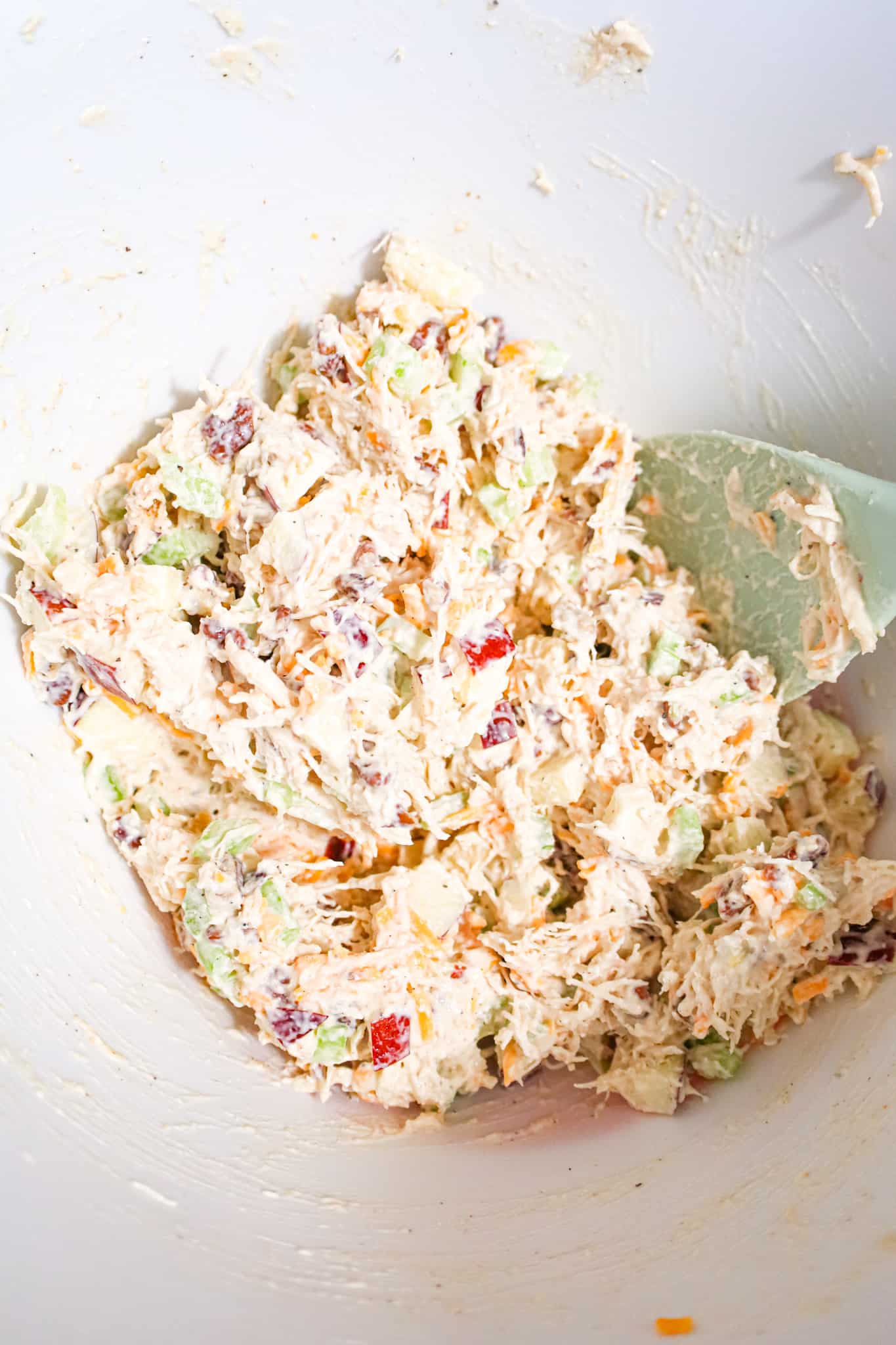 creamy chicken salad mixture with diced apples in a mixing bowl