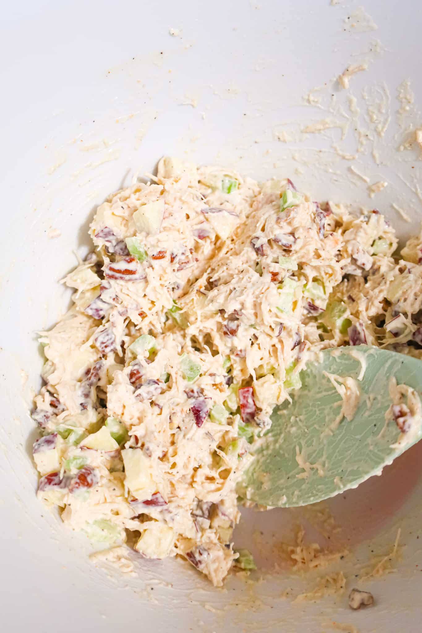 creamy chicken salad mixture with celery in a mixing bowl