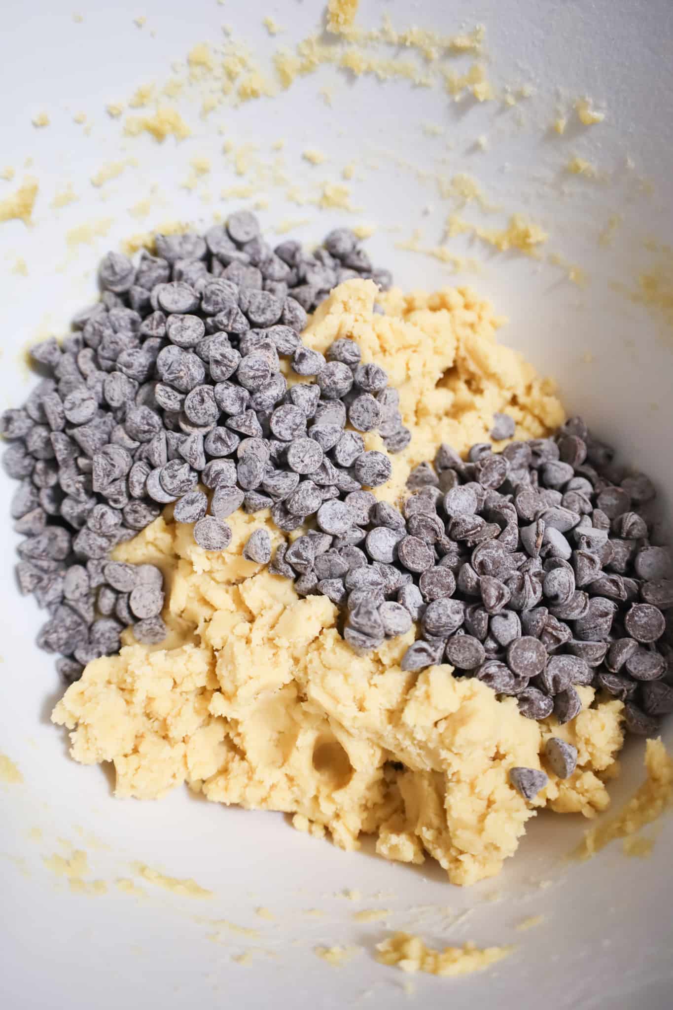 semi sweet chocolate chips on top of dough in a mixing bowl