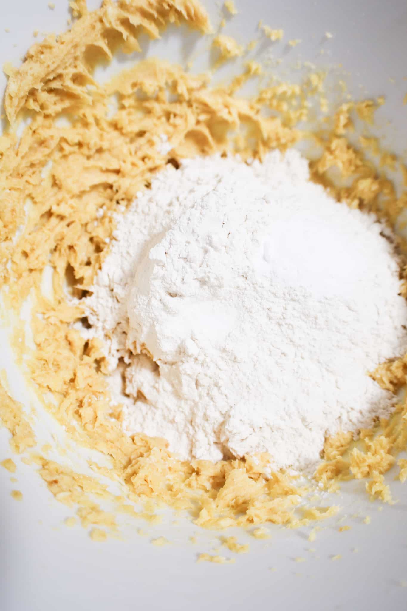 flour, salt and baking soda on top of creamed sugar mixture in a mixing bowl