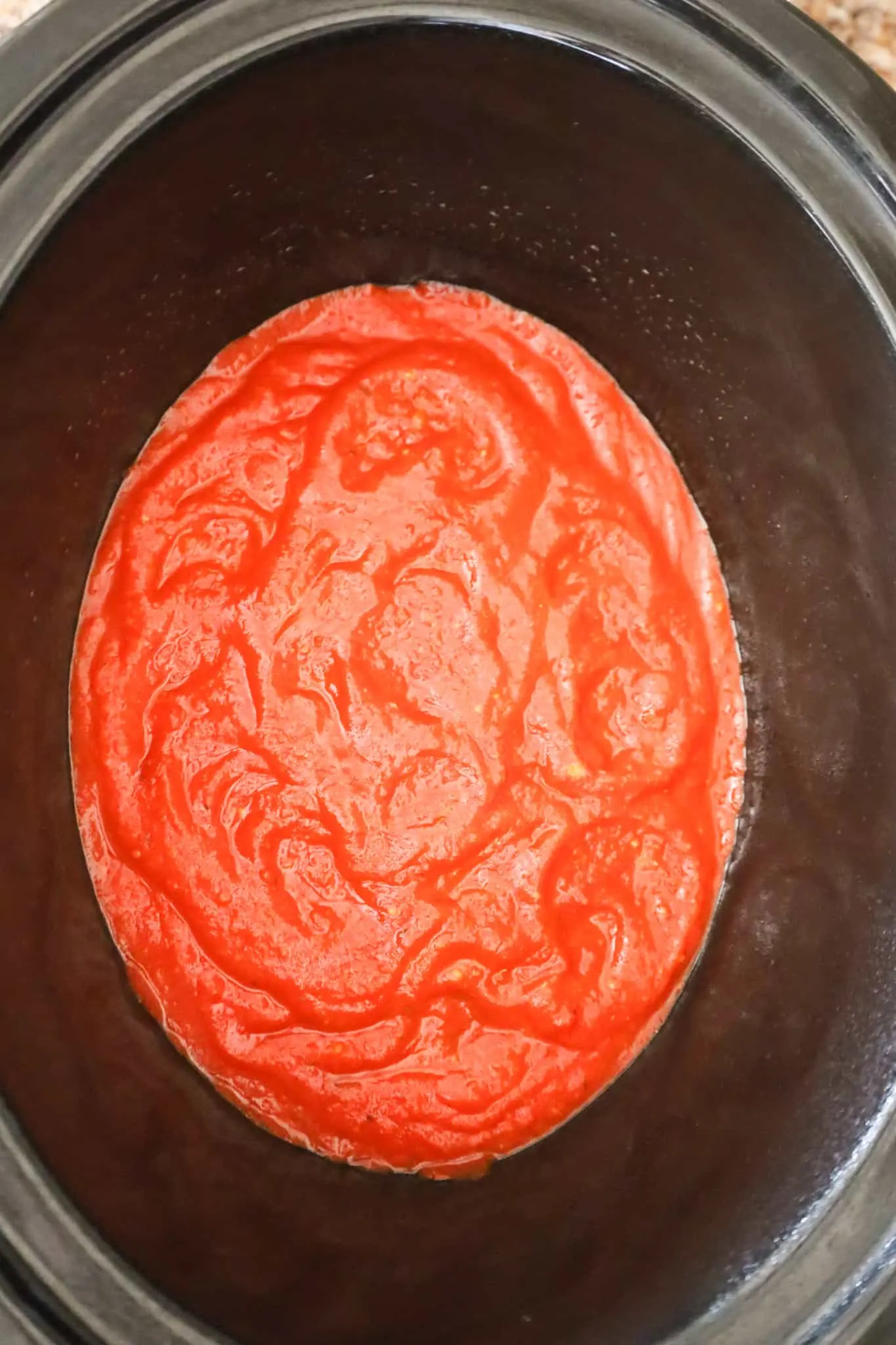 marinara sauce in the bottom of a crock pot