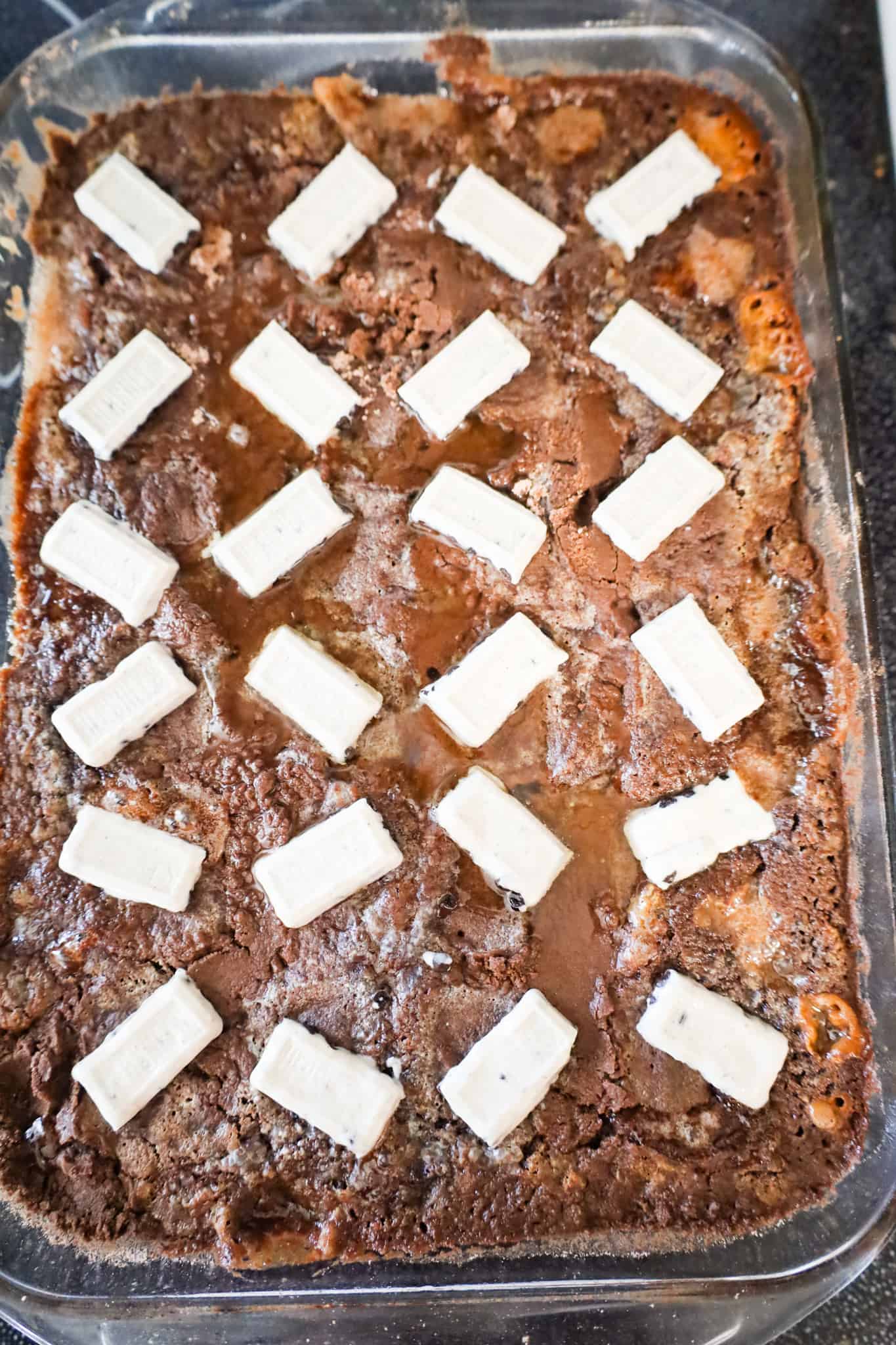 Hershey's cookies and cream bar pieces on top of chocolate cake in a baking dish