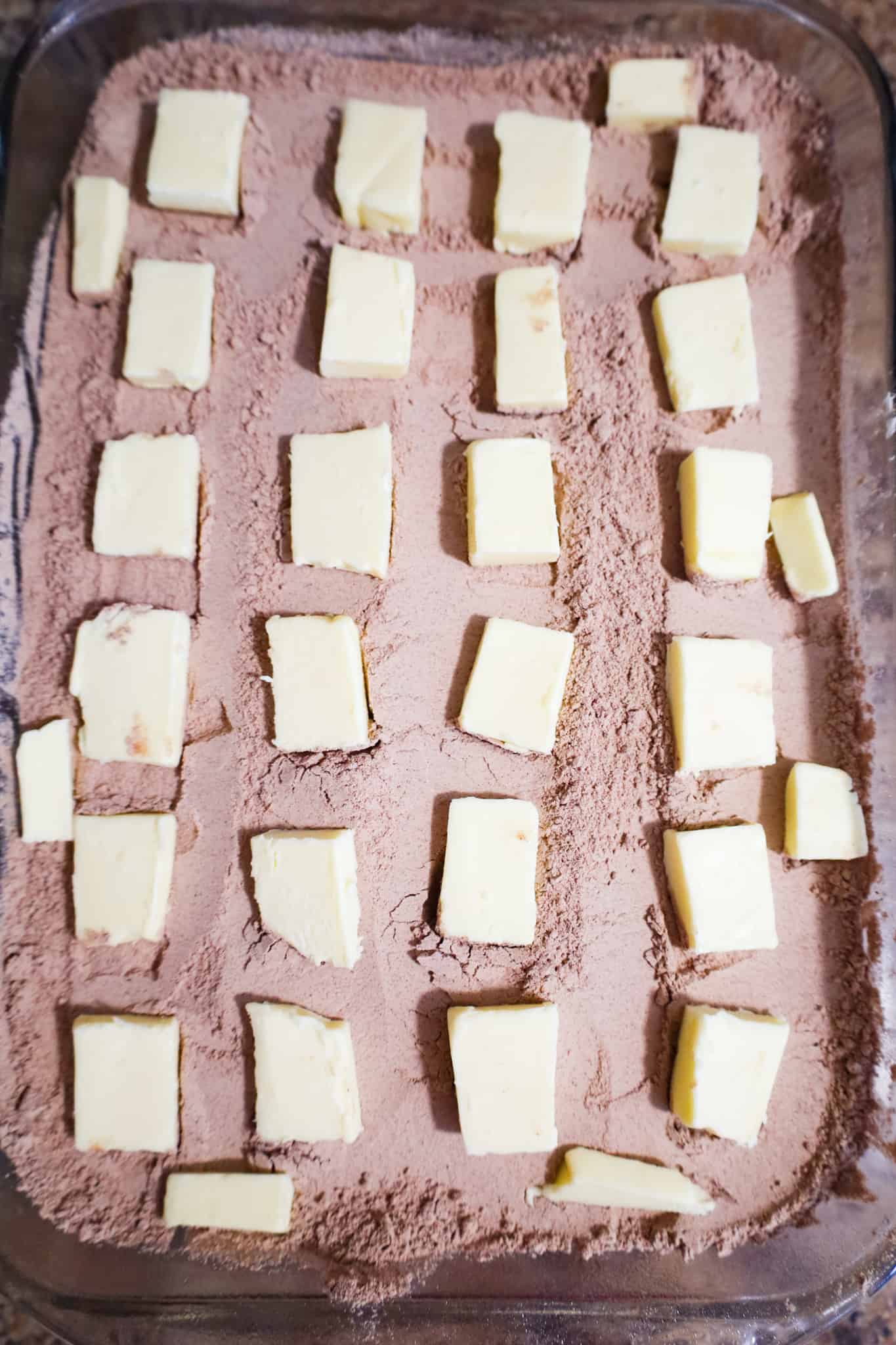 butter chunks on top of cake mix in a baking dish