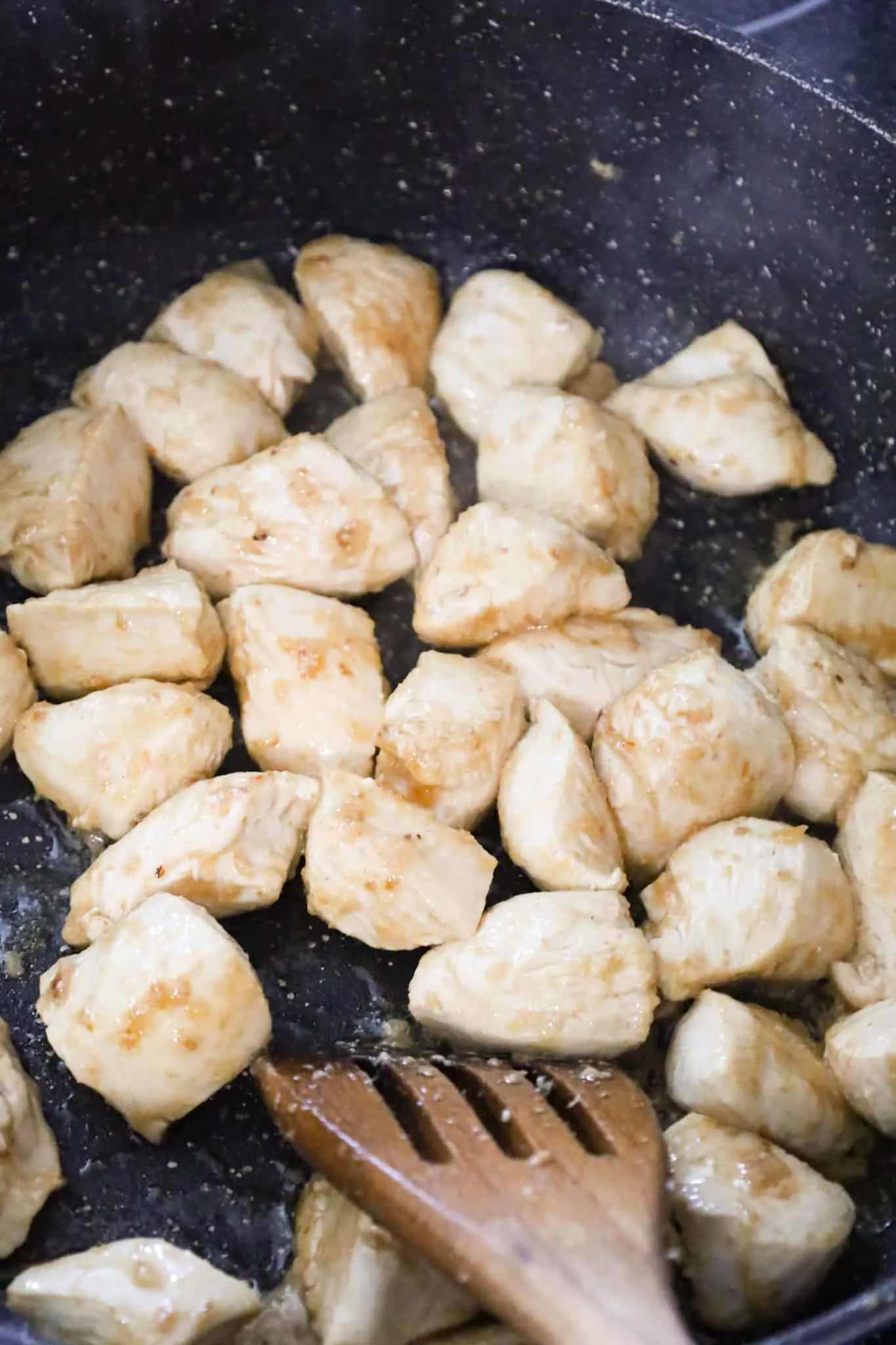 chicken breast chunks cooking in a saute pan
