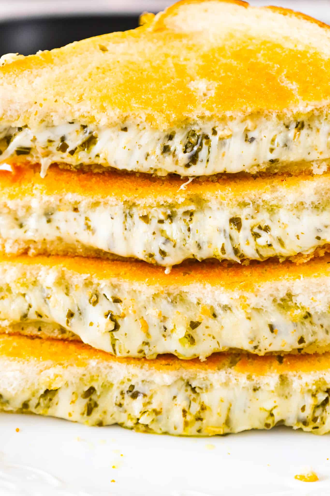 Pesto Grilled Cheese is an easy lunch or dinner recipe with buttered bread filled with gooey mozzarella, parmesan and basil pesto.