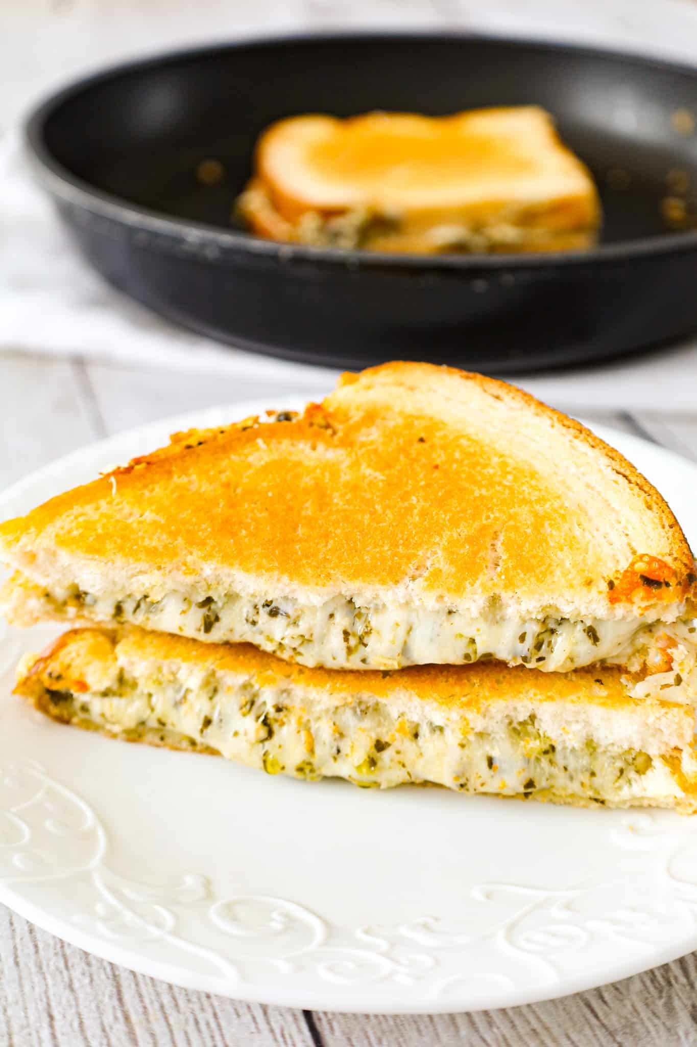 Pesto Grilled Cheese is an easy lunch or dinner recipe with buttered bread filled with gooey mozzarella, parmesan and basil pesto.