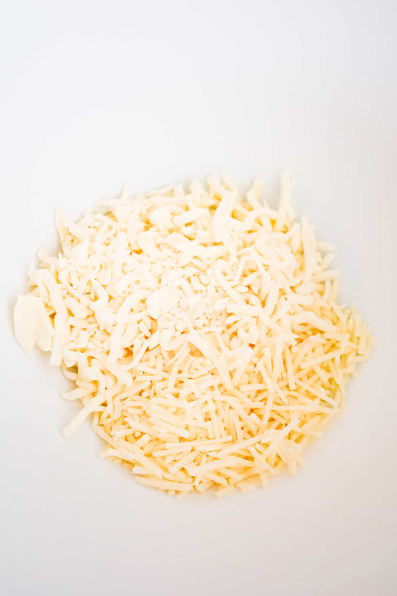 shredded mozzarella and shredded parmesan cheese in a mixing bowl