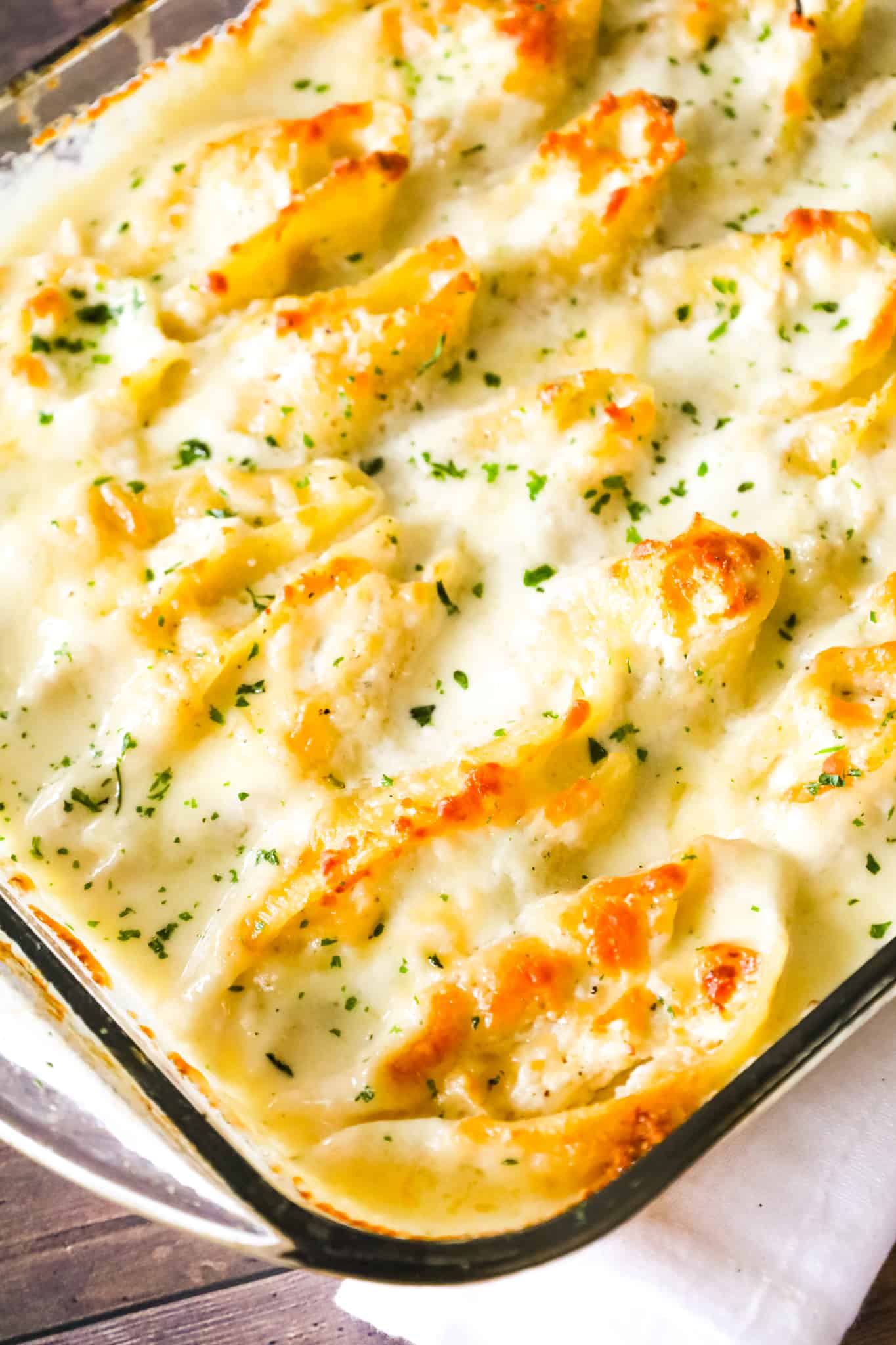 Chicken Alfredo Stuffed Shells are a delicious baked pasta recipe loaded with ricotta cheese, shredded chicken, mozzarella and parmesan all in a creamy garlic sauce.