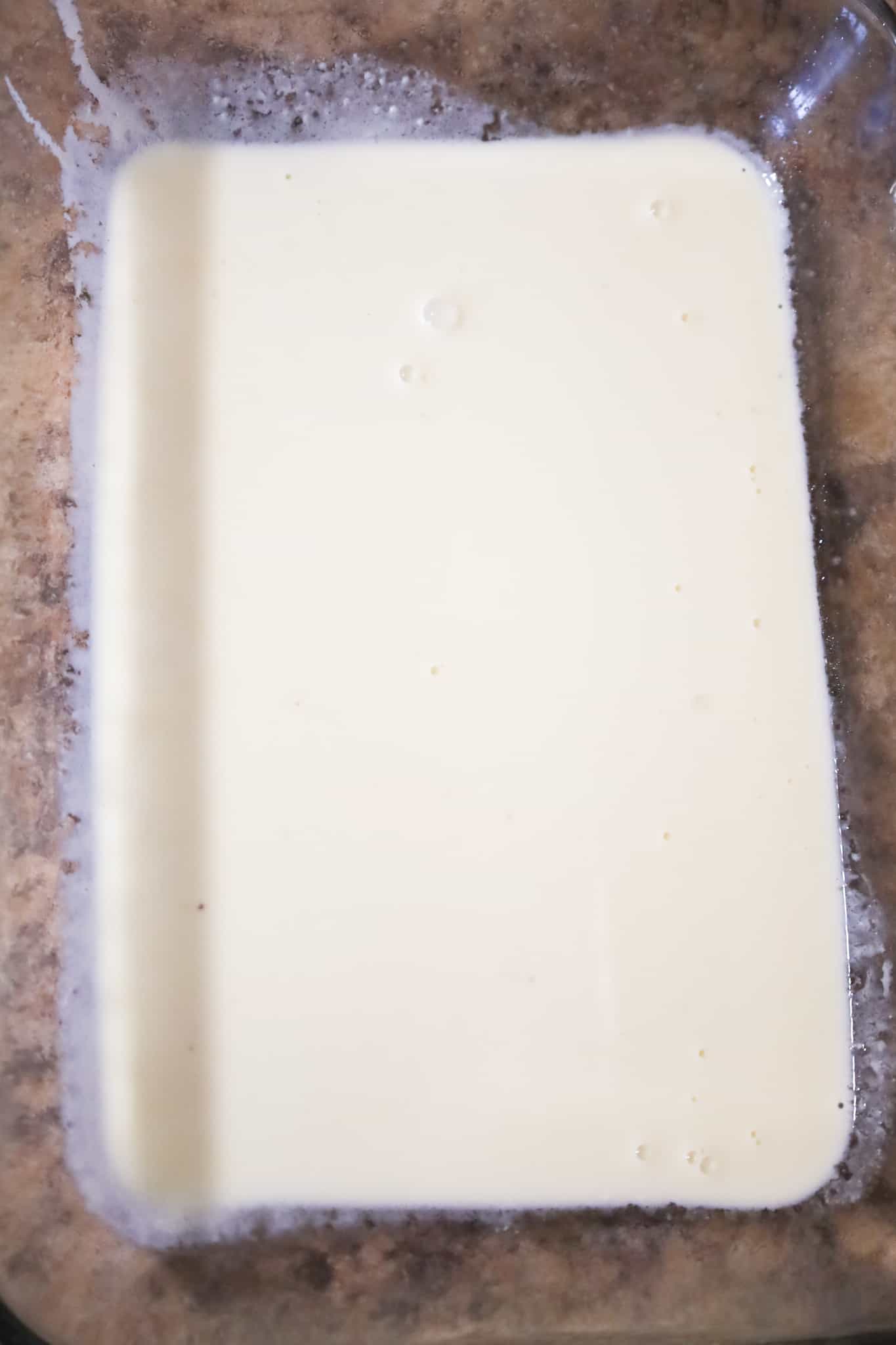 creamy alfredo sauce in the bottom of a baking dish