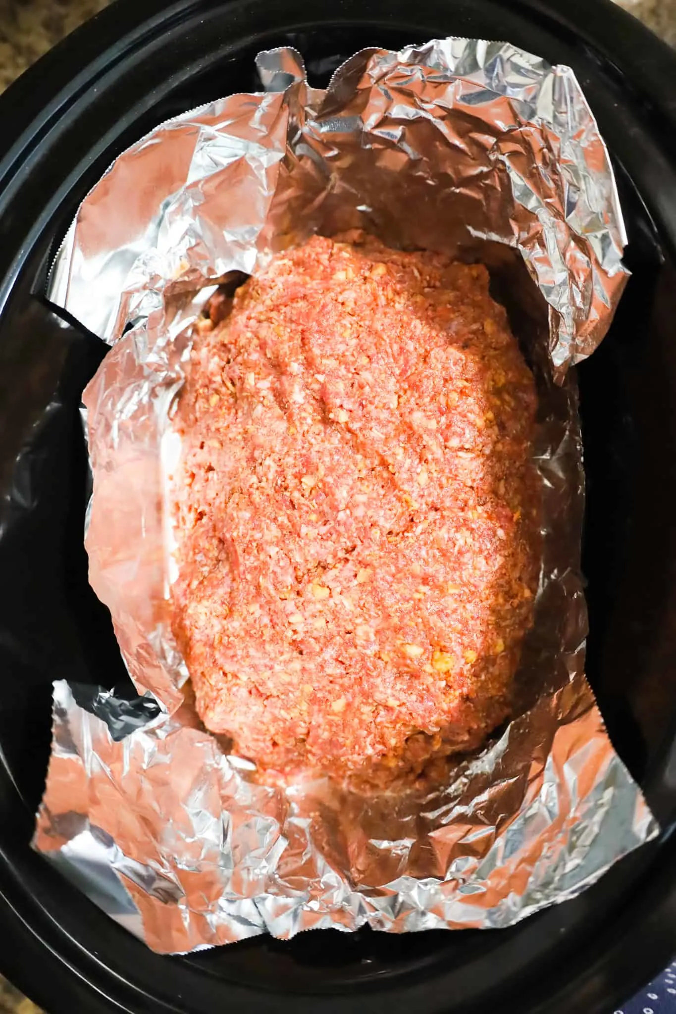 raw meatloaf mixture in a foil lined crock pot