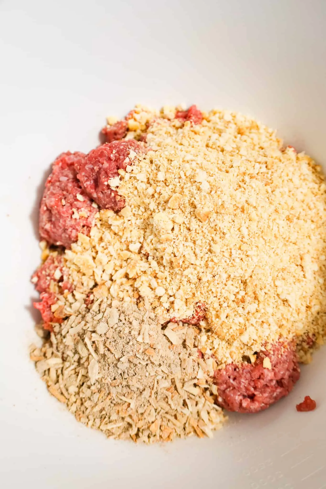 Lipton onion soup mix and crushed Ritz crackers on top of raw ground beef in a mixing bowl