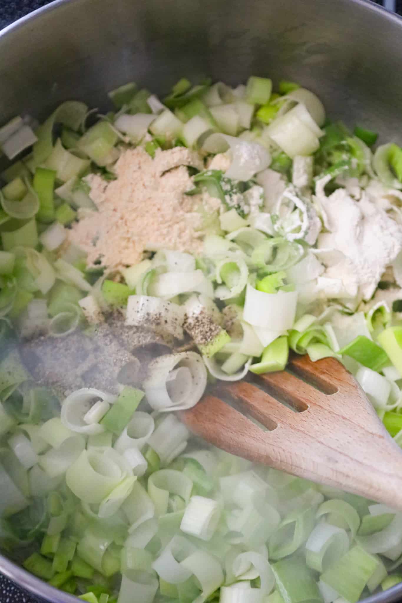 spices on top of chopped leeks in a large pot